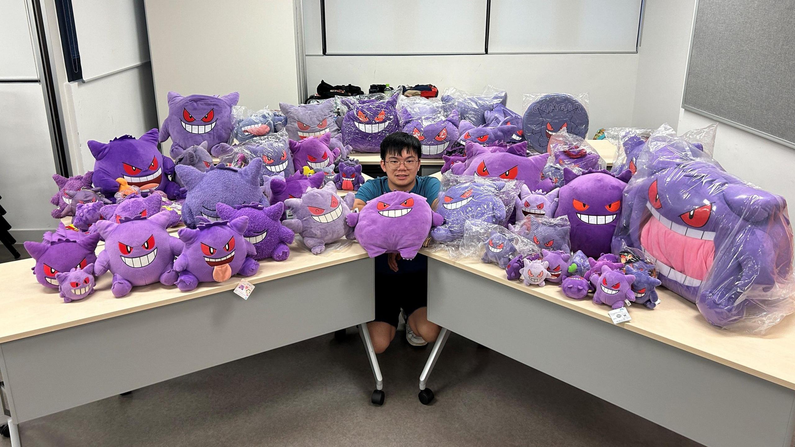 Tsang Cheuk Tip surrounded by Gengar toys.