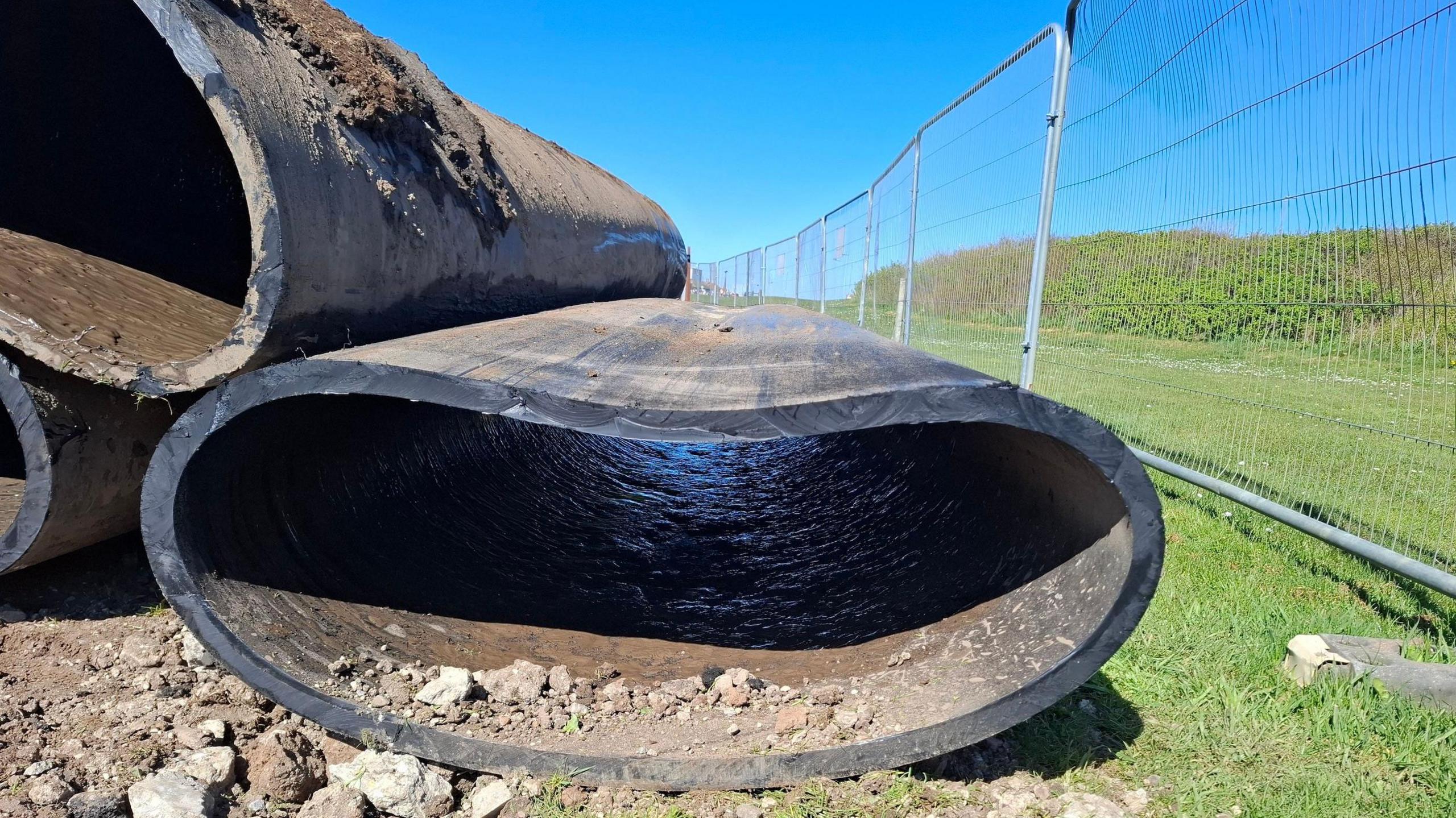 A large plastic pipe which has been squeezed into a flat oval shape.
