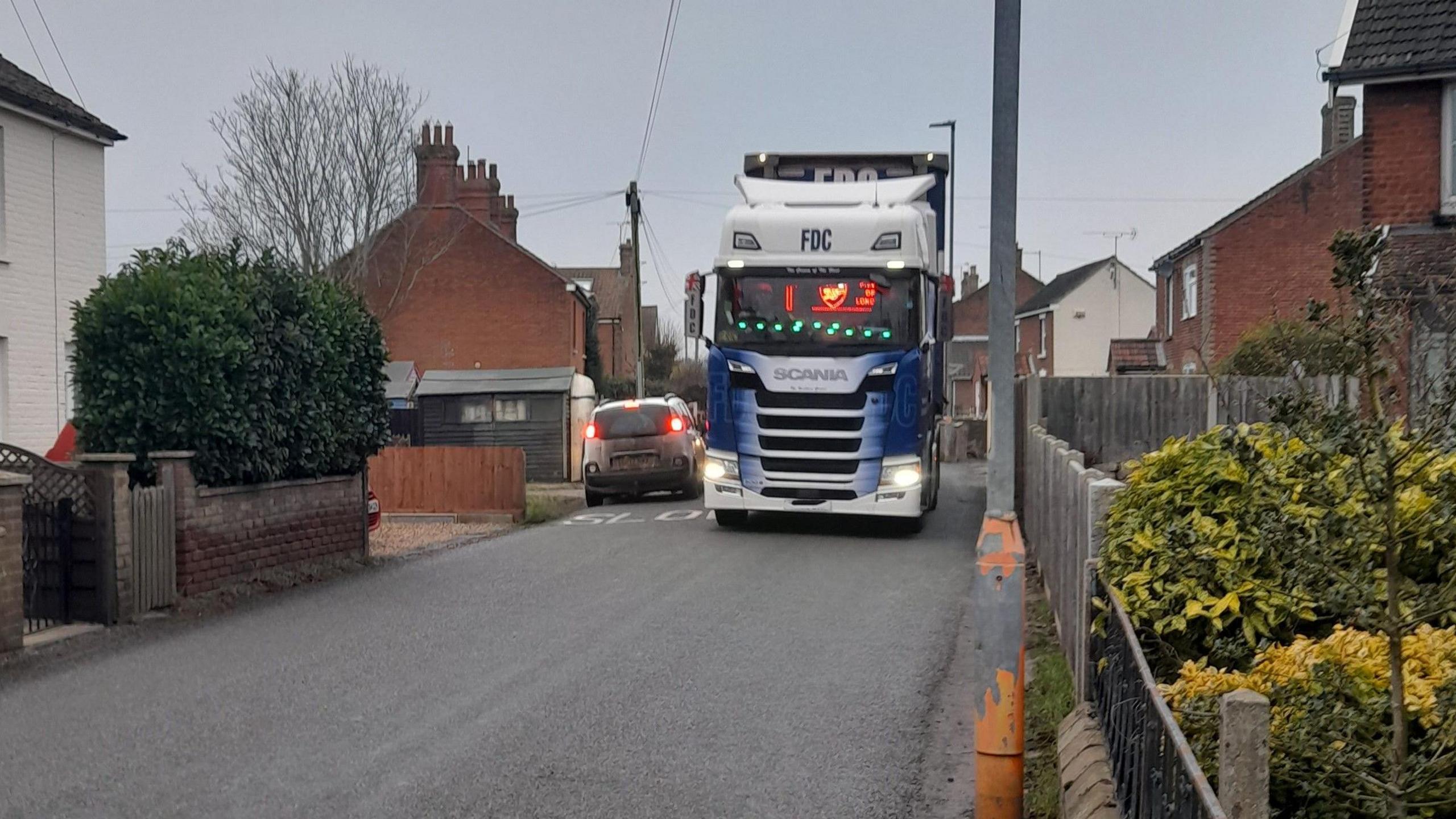 A car and a lorry squeeze down past each other in Aylsham Road as they head in different directions down the narrow road