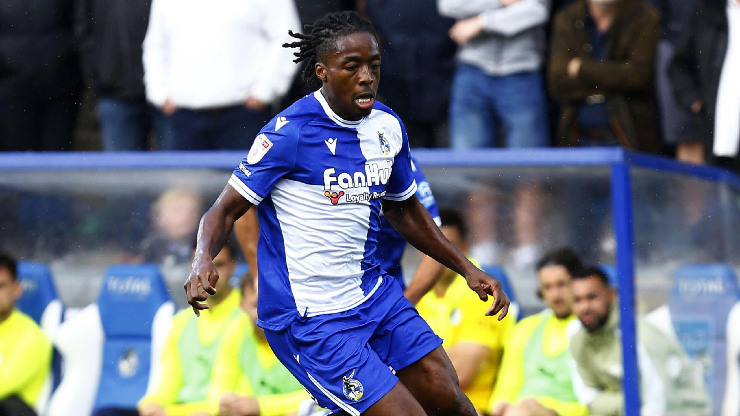 Steve Evans speaking passionately on the sidelines during a Bristol Rovers match, gesturing emphatically to players.