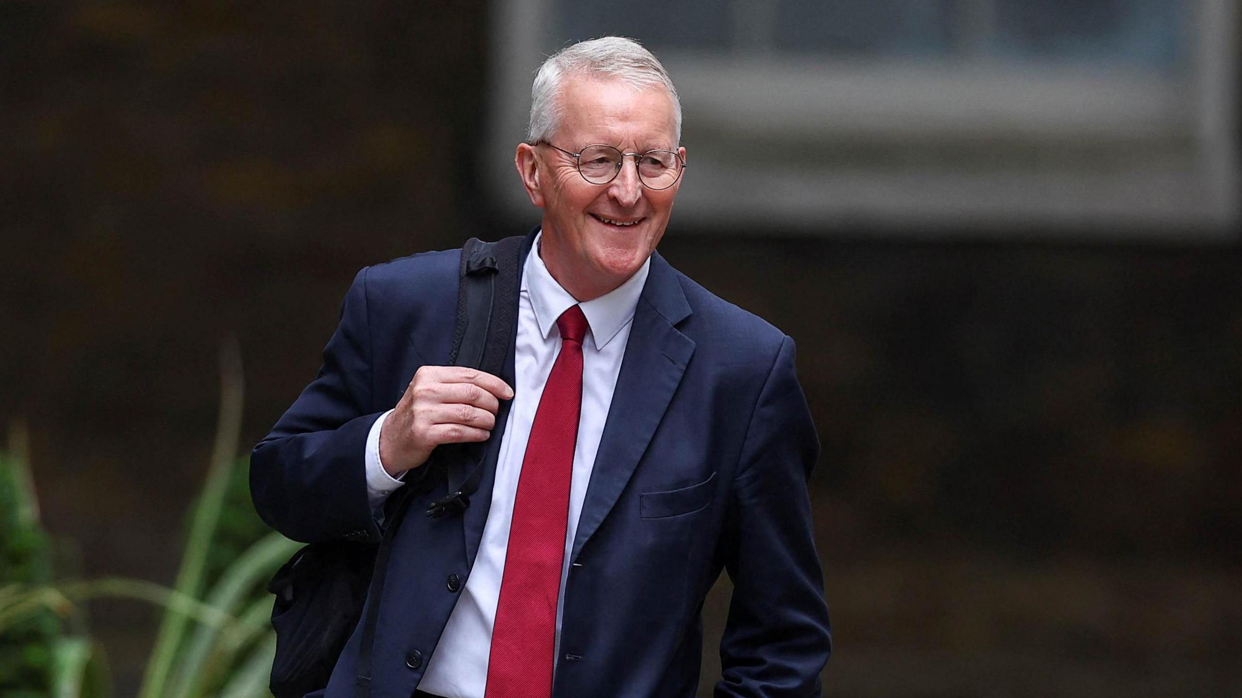 Hilary Benn holding a backpack on his way to 10 Downing Street