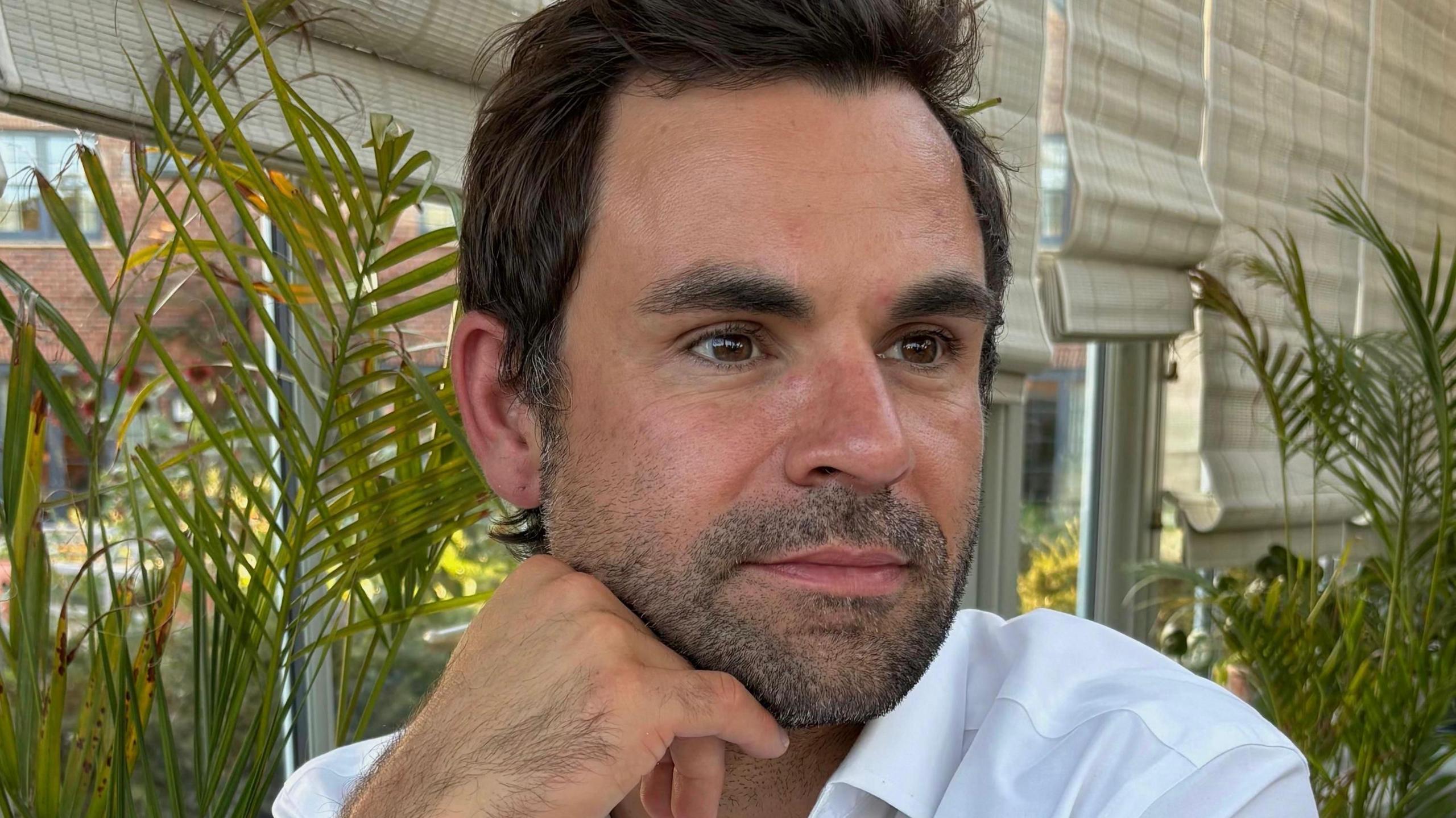 Close up image of James Talbot who has brown hair and eyes and is wearing a white shirt.