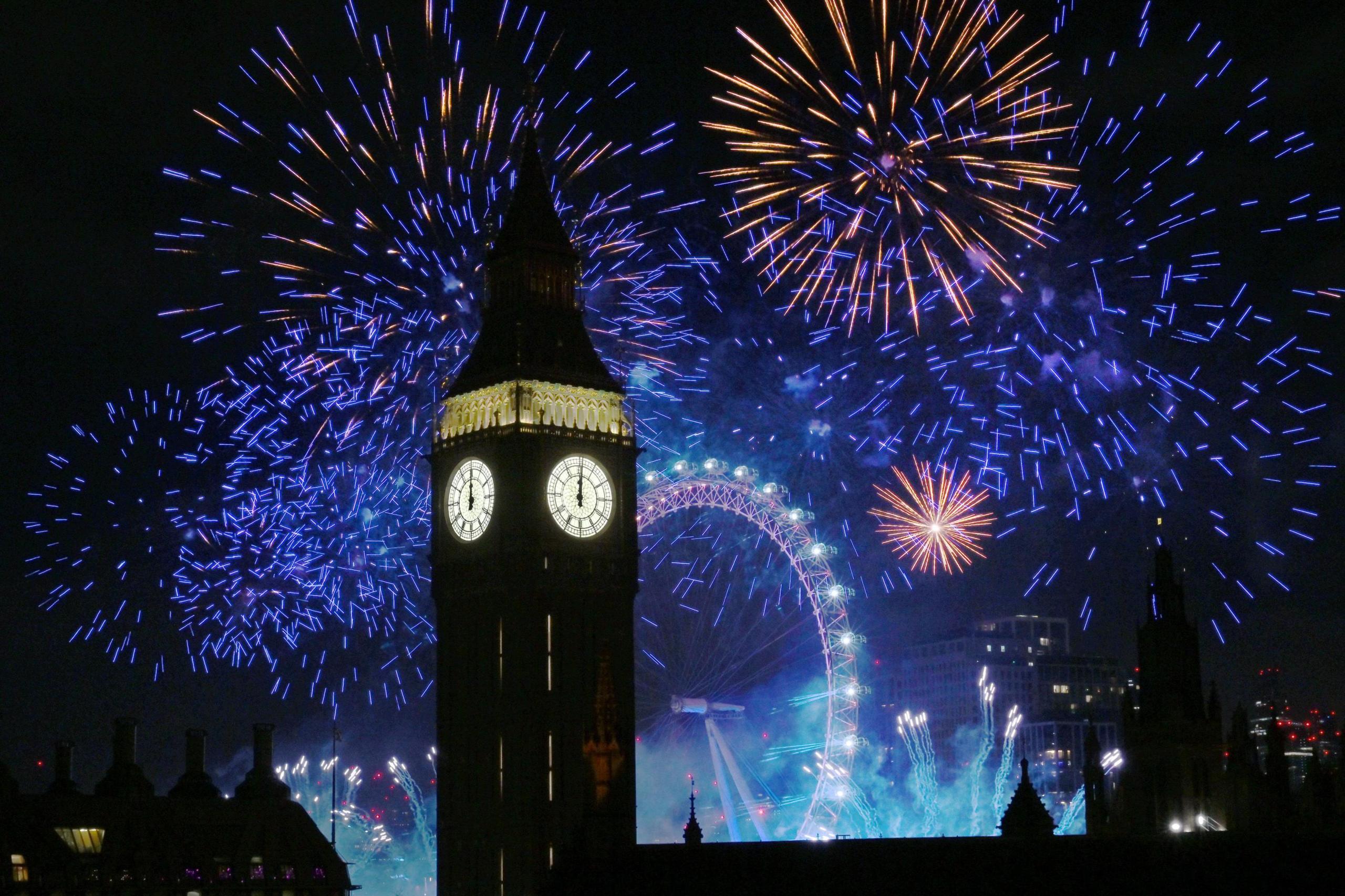 Spectacular fireworks in colours of blue and orange light up the night sky behind the Elizabeth Tower (Big Ben), London, on New Year's Eve. 