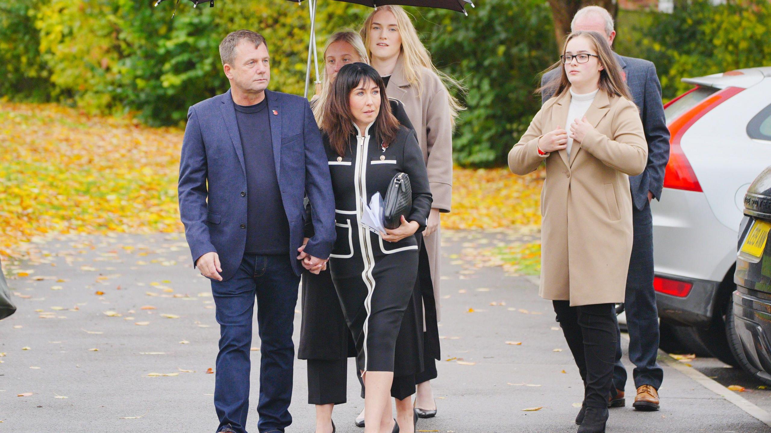 Anthony Beck (left) and Leighann McCready (centre), the parents of Jaysley Beck, arriving at Bulford Court Martial Centre in Wiltshire. They are accompanied by three other girls and a man at the back.