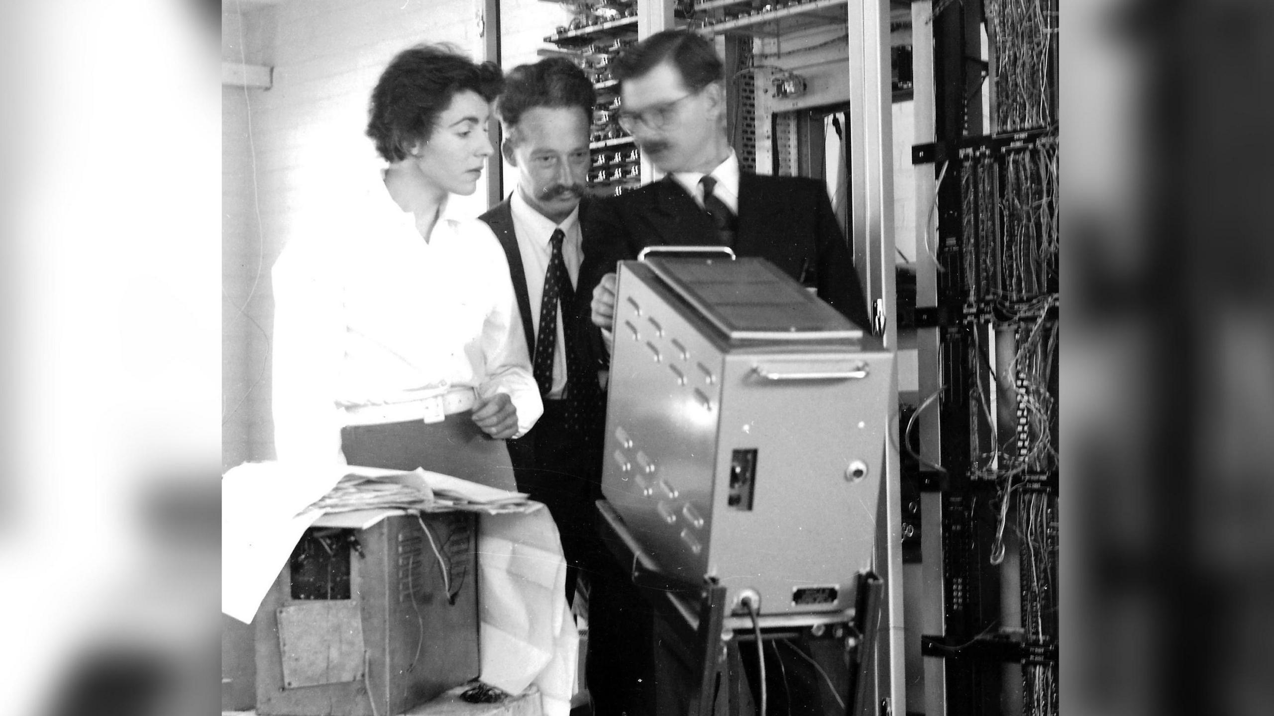 Dame Stephanie Shirley with two men and a computer