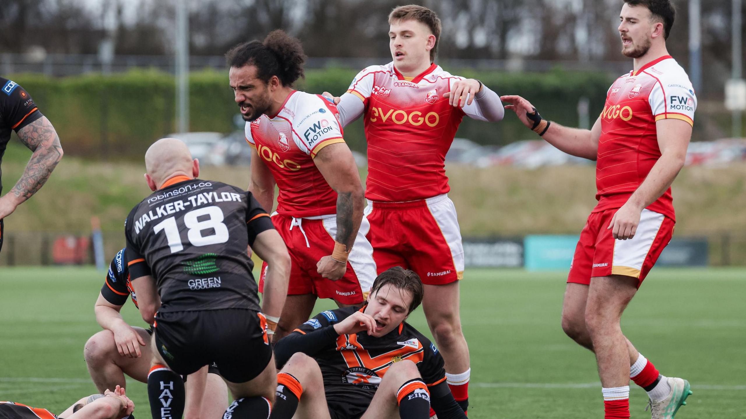 Joel Farrell celebrates with a muscle-flexing pose after scoring for Sheffield against Whitehaven, as opposing players look on ruefully