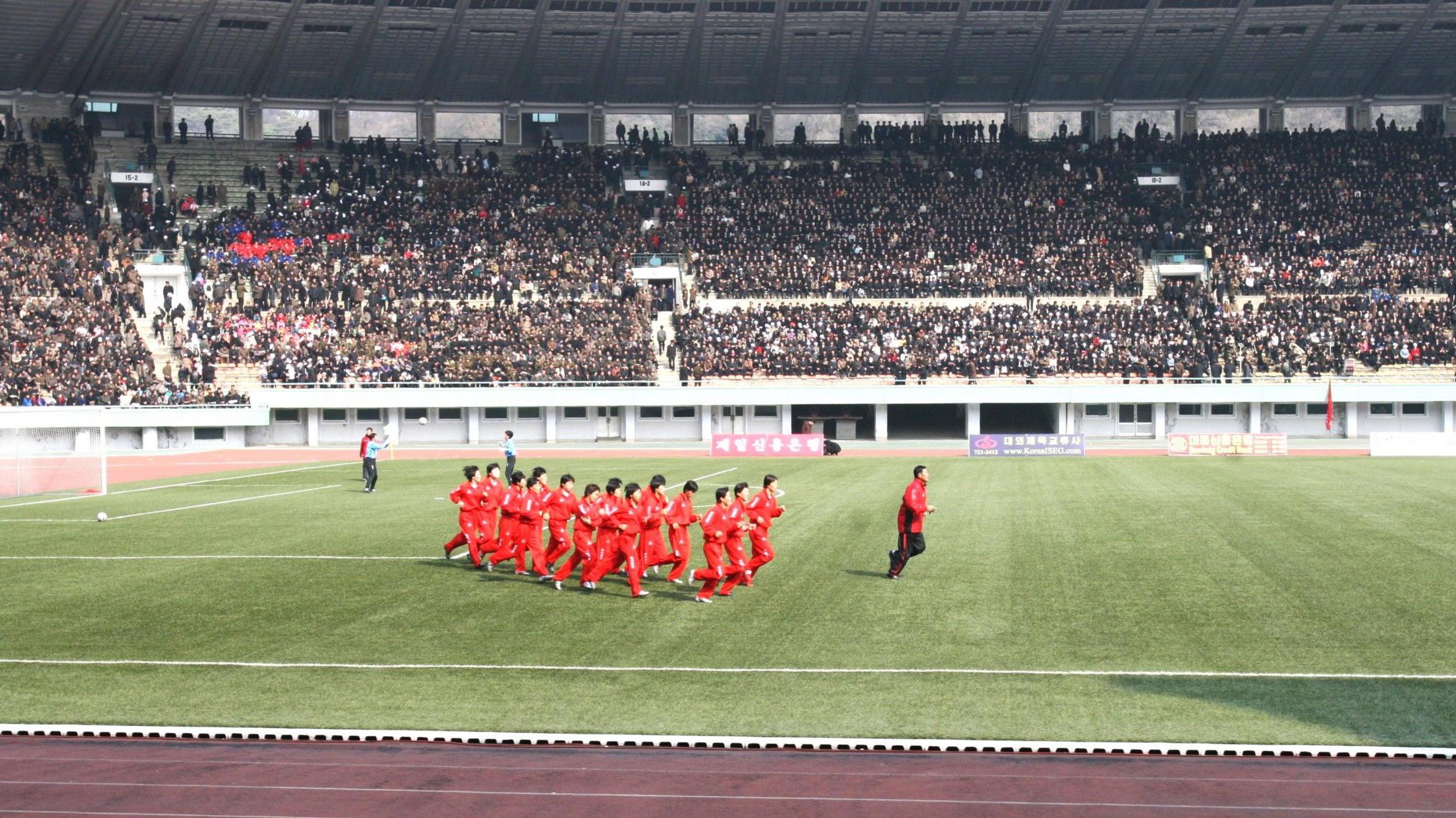 North Korea women warm up with a jog around the pitch in Pyongyang