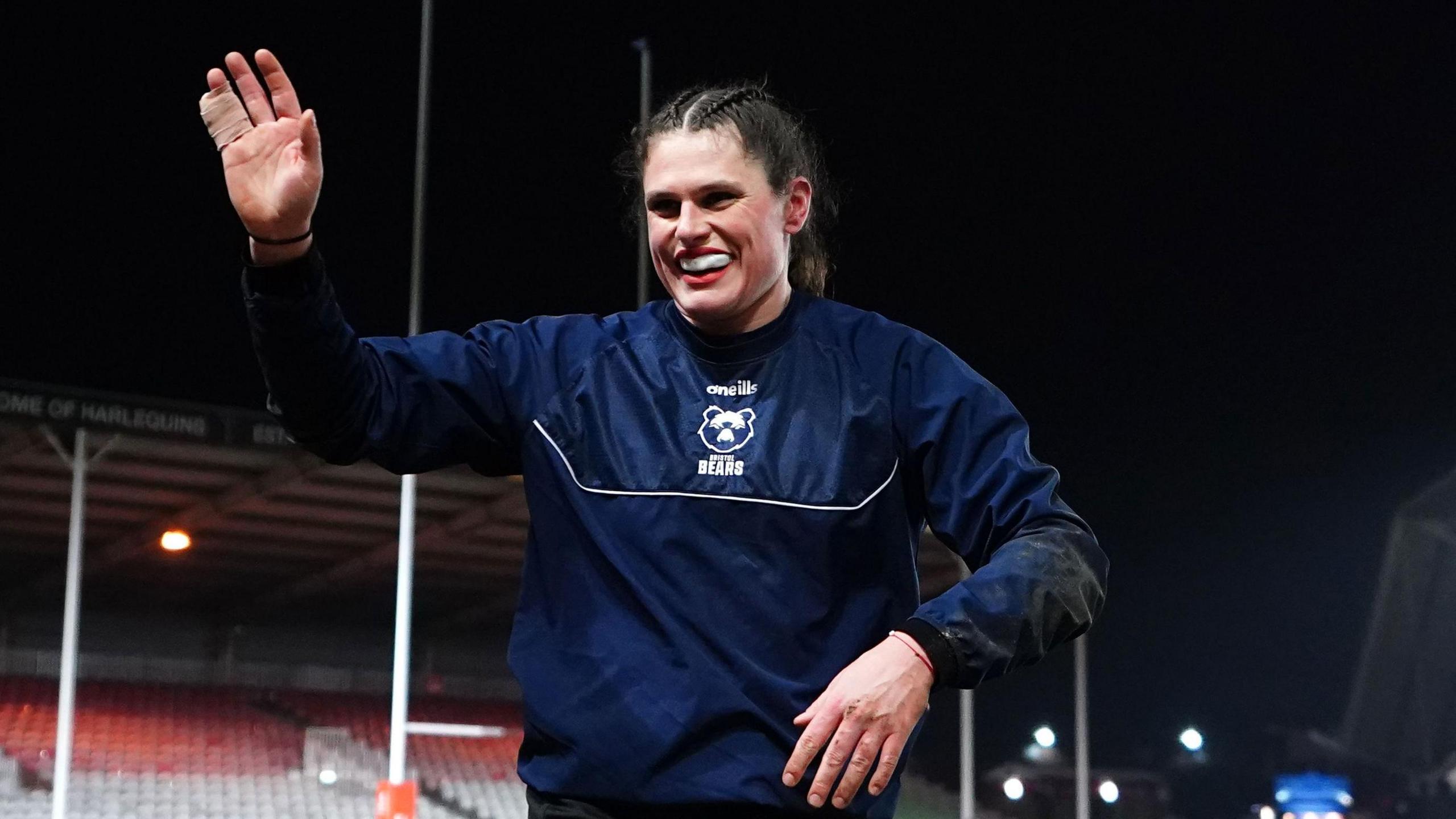 Ilona Maher waves to fans while on the field