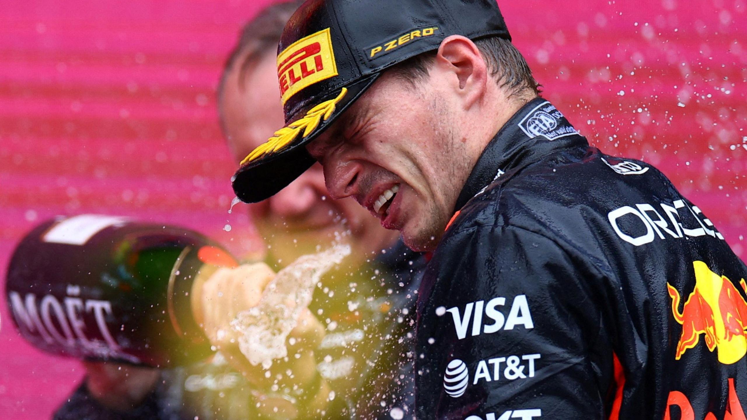 A Red Bull team member sprays champagne on Max Verstappen after the Dutchman won the Azerbaijan Grand Prix