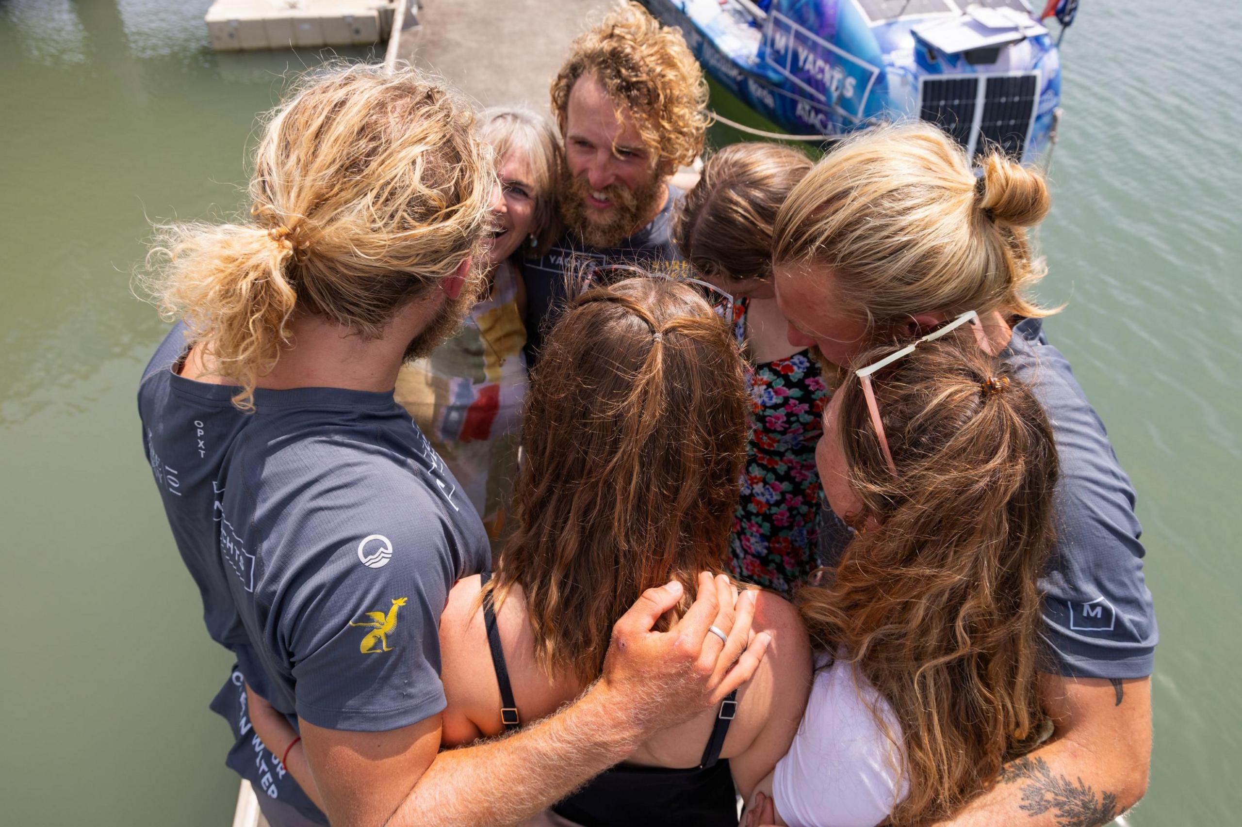 The brothers hug family and friends after arriving in Cairns.
