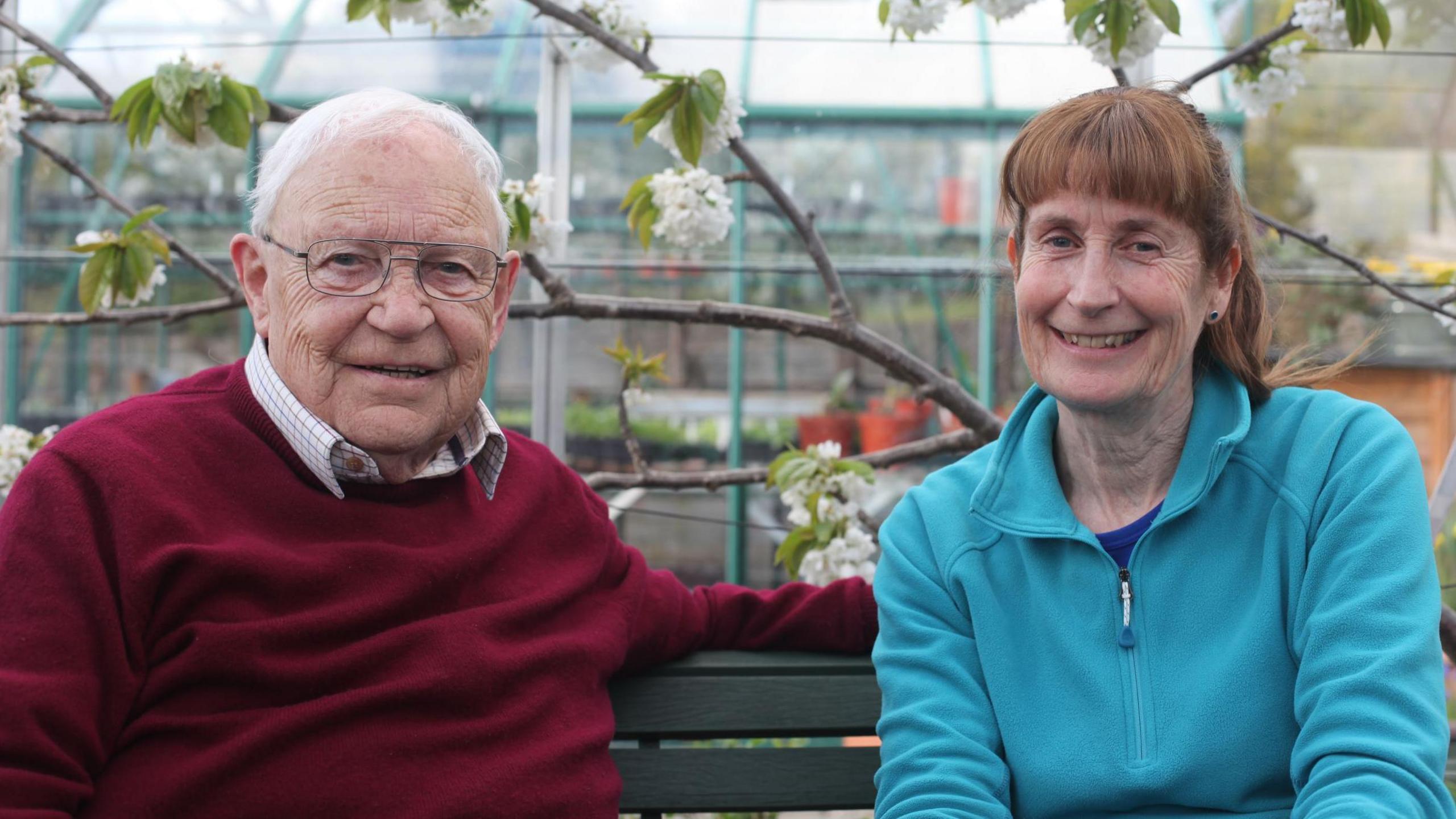 Jim McColl and Carole Baxter on a bench, smiling