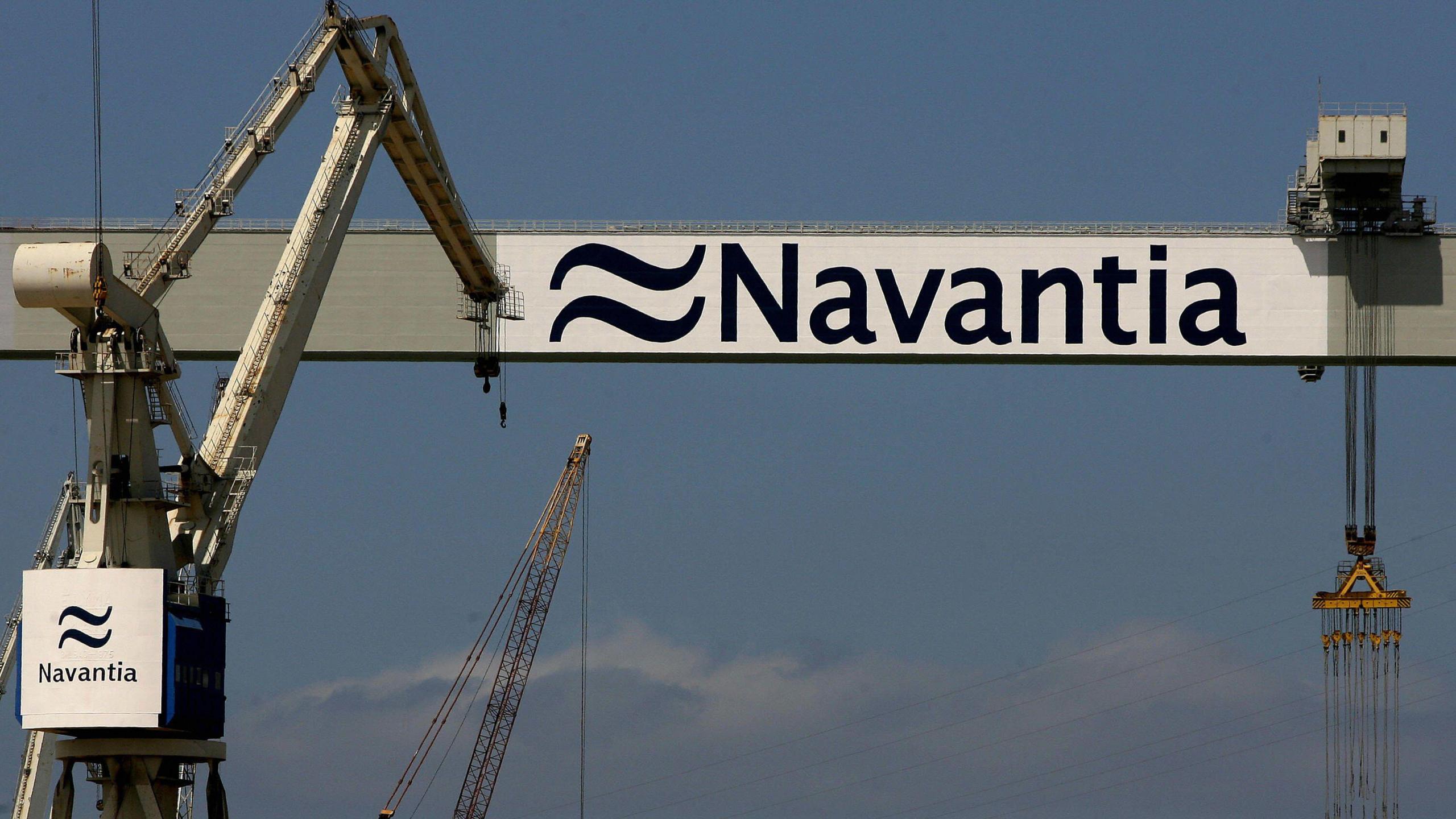 Cranes of Spanish state-owned military shipyard Navantia. There are some clouds in the sky.