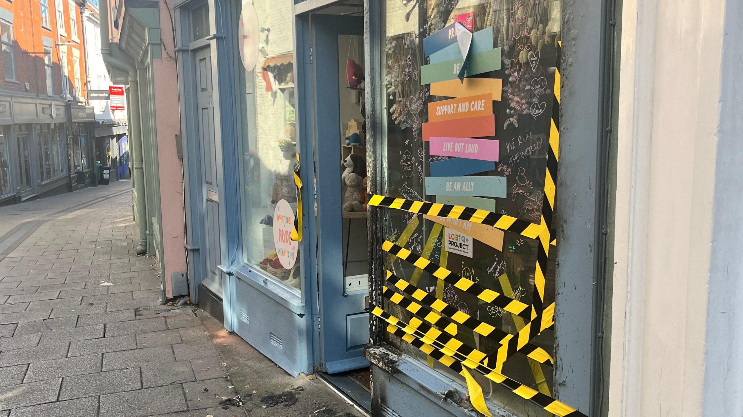 Damage to the Lisa Angel shop on Lower Goat Lane . Black and yellow tape has been put across the window