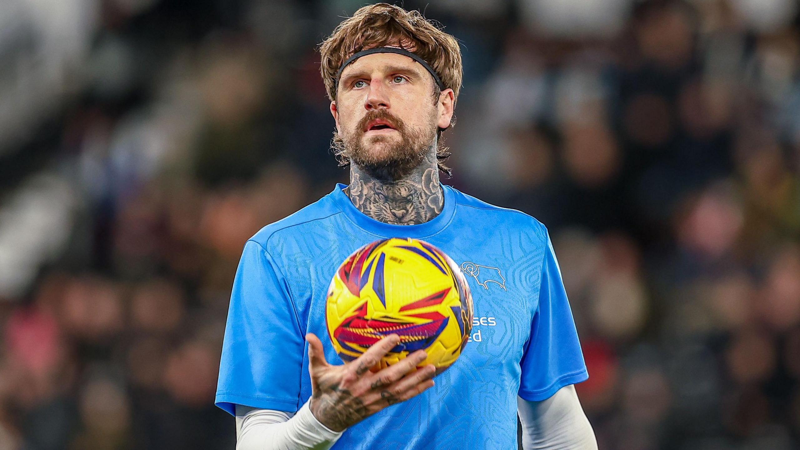 Sonny Bradley with a football in hand while warming up for Derby