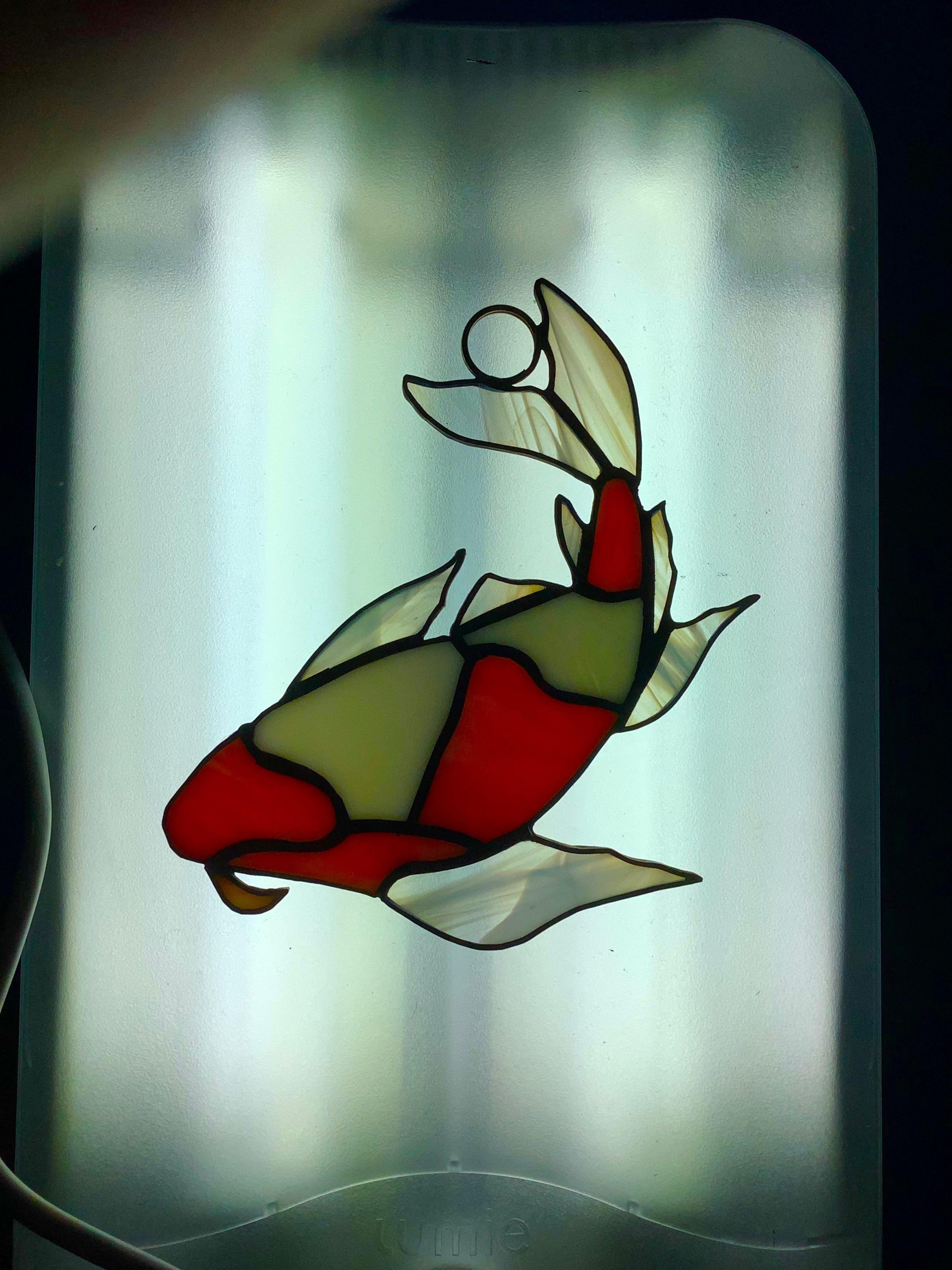 Stained glass koi carp in front of a window