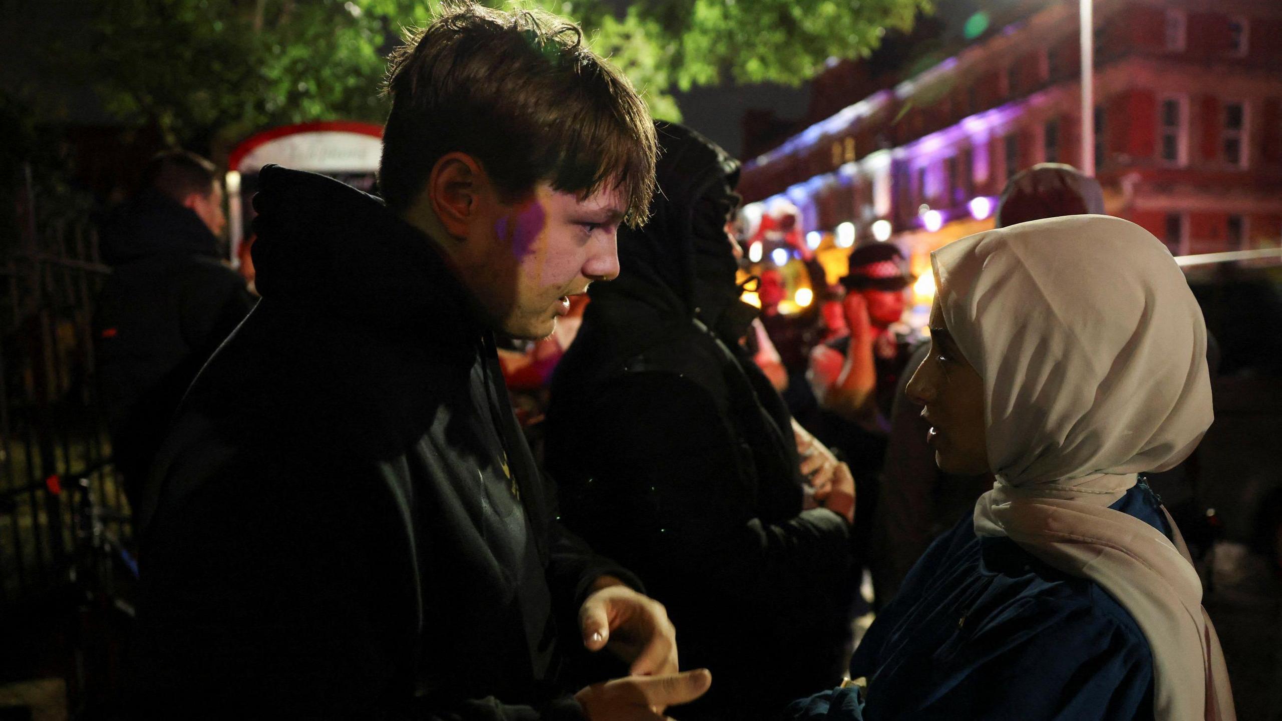 Protester in discussion with a Muslim woman