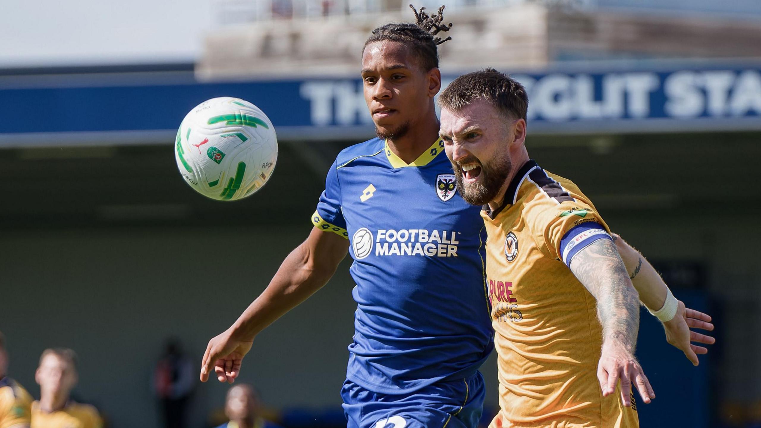 Alistair Smith AFC Wimbledon puts Newport captain Kyle Cameron under pressure