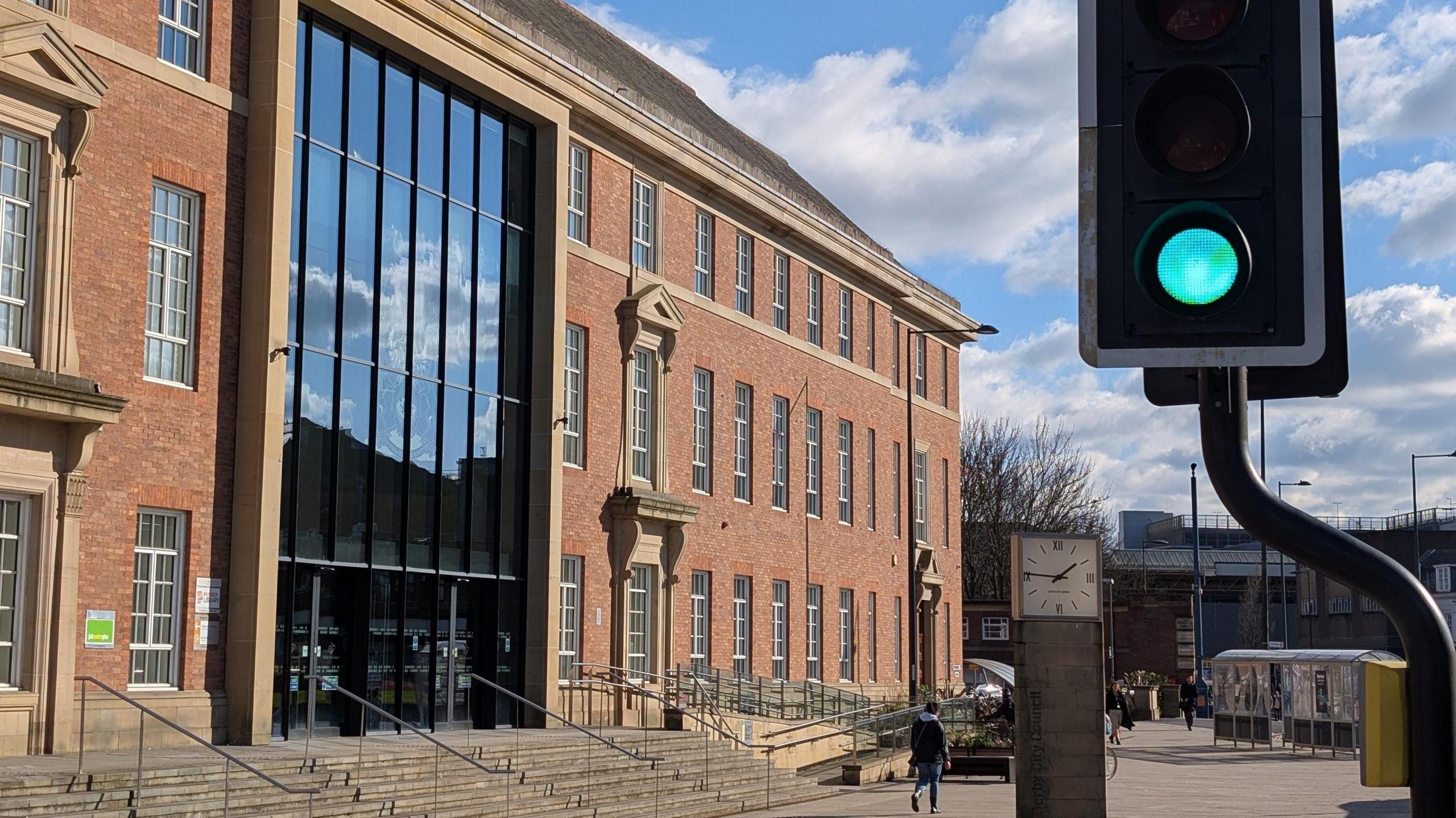 A traffic light, on green, in front of Derby's council headquarters.