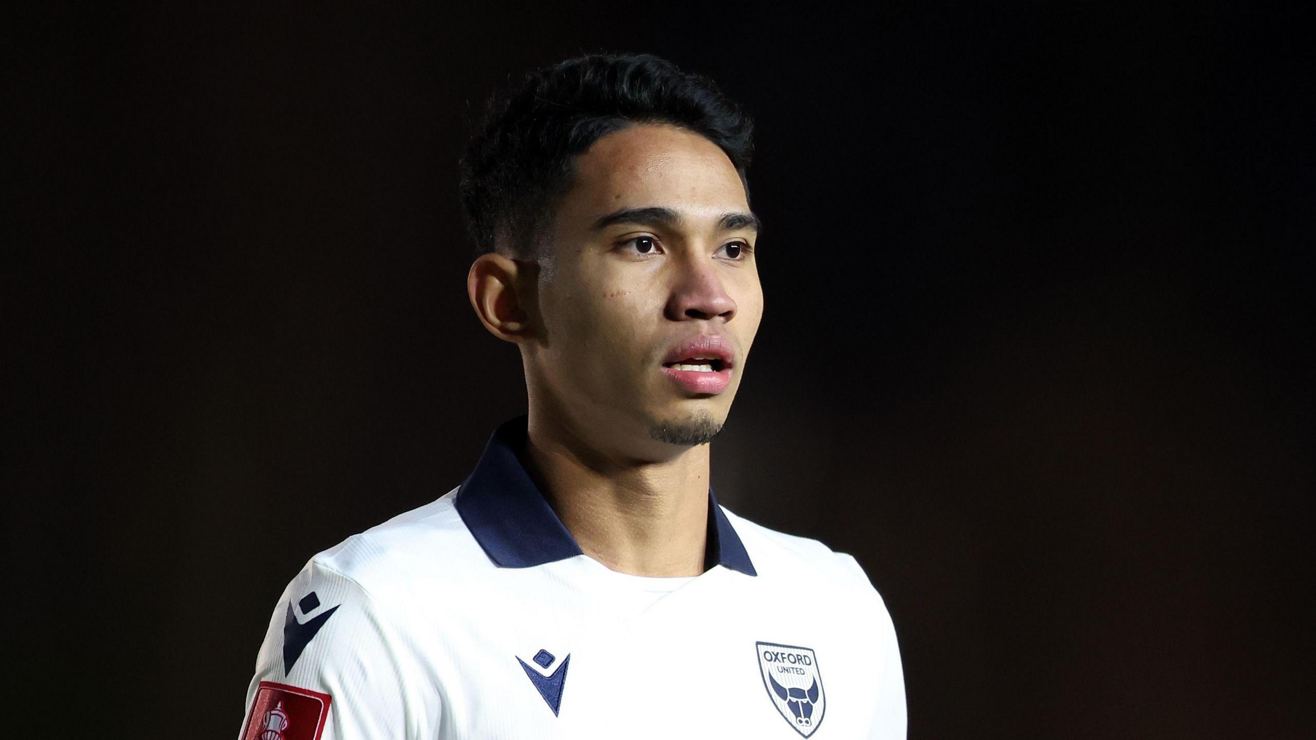 Marselino Ferdinan standing on the pitch wearing Oxford United kit