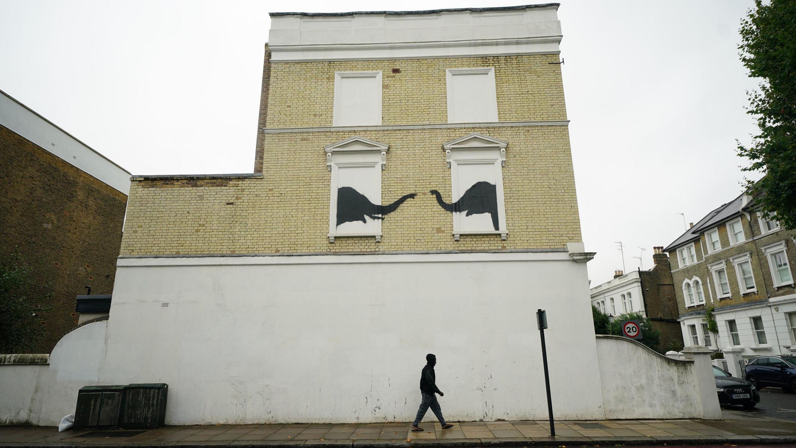 Banksy artwork depicting two elephants reaching out to one another from building's false windows