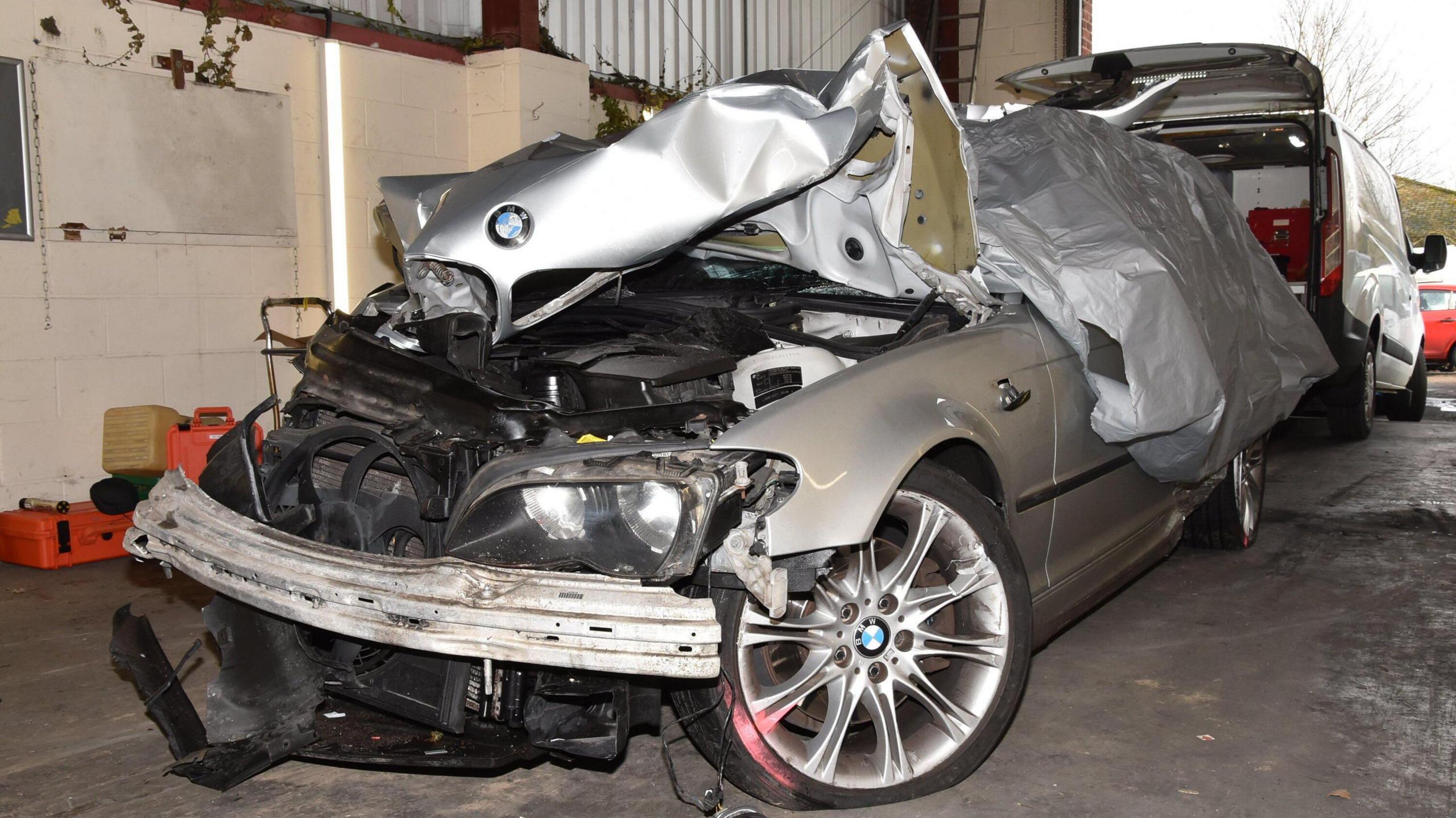 The silver BMW car can be seen smashed up in the front