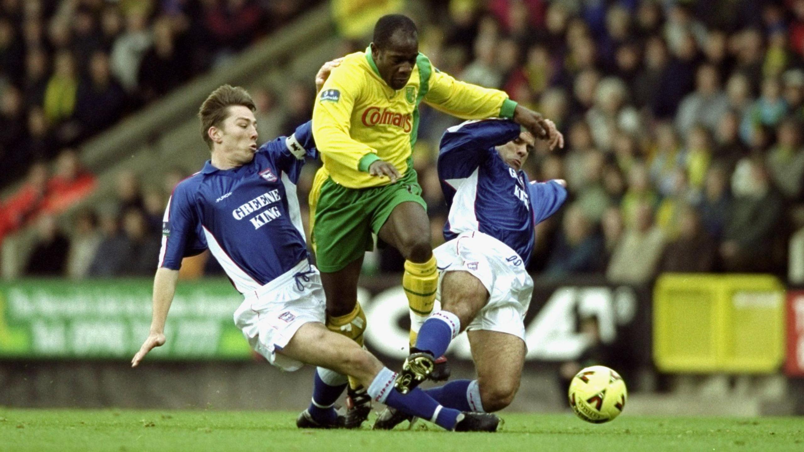 Adrian Forbes is tackled by two Ipswich Town players while playing against them for Norwich City in 1999