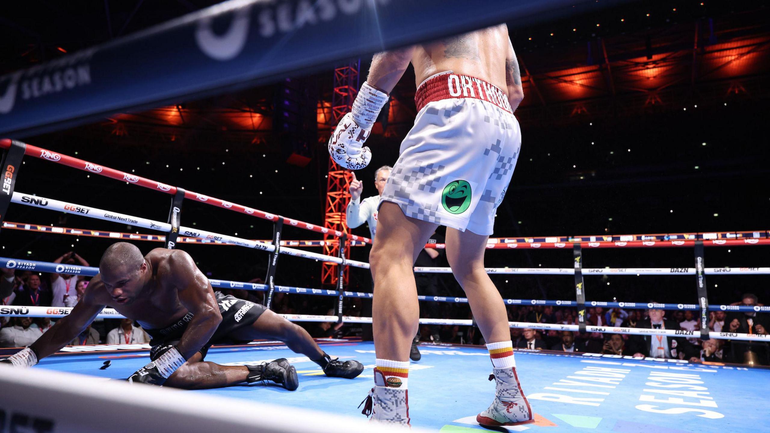 Daniel Dubois on the canvas with Oleksandr Usyk standing over him