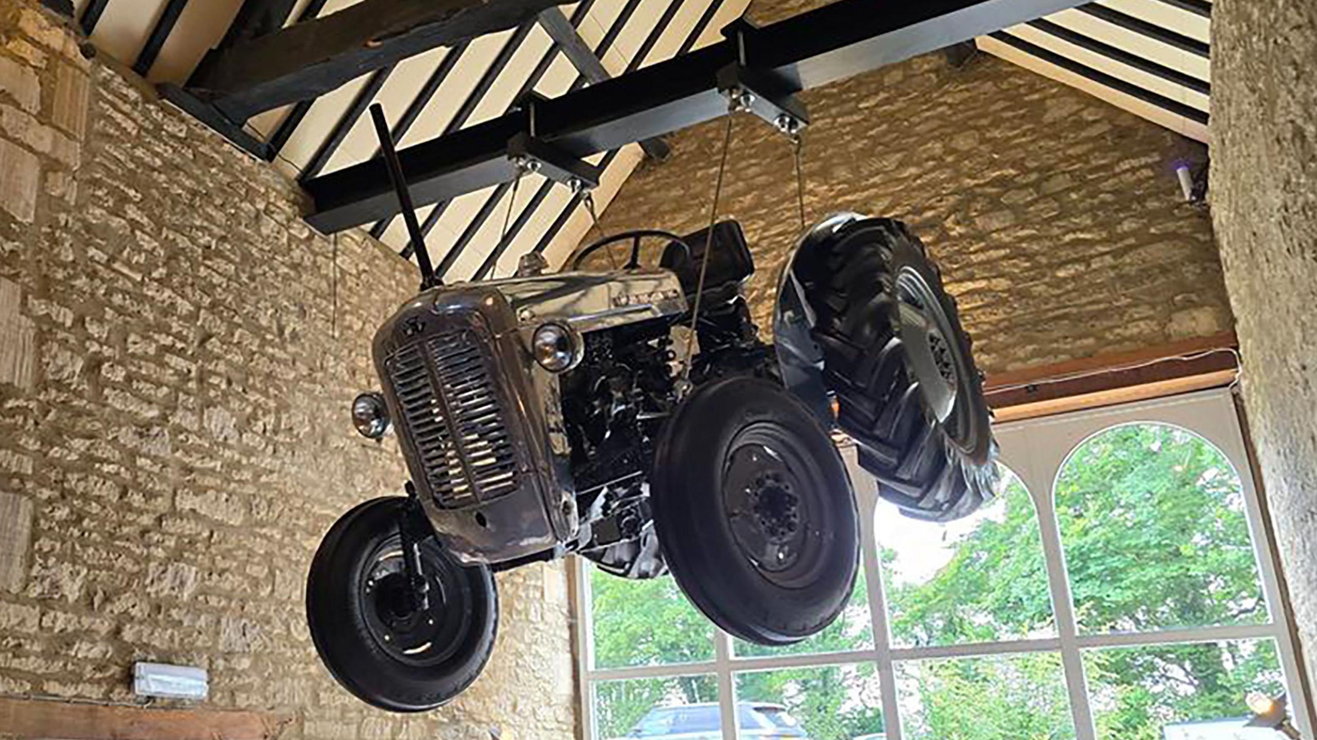 A silver tractor suspended from a rafter in Jeremy Clarkson's new pub, The Farmer's Dog, in Asthall, near Burford in Oxfordshire