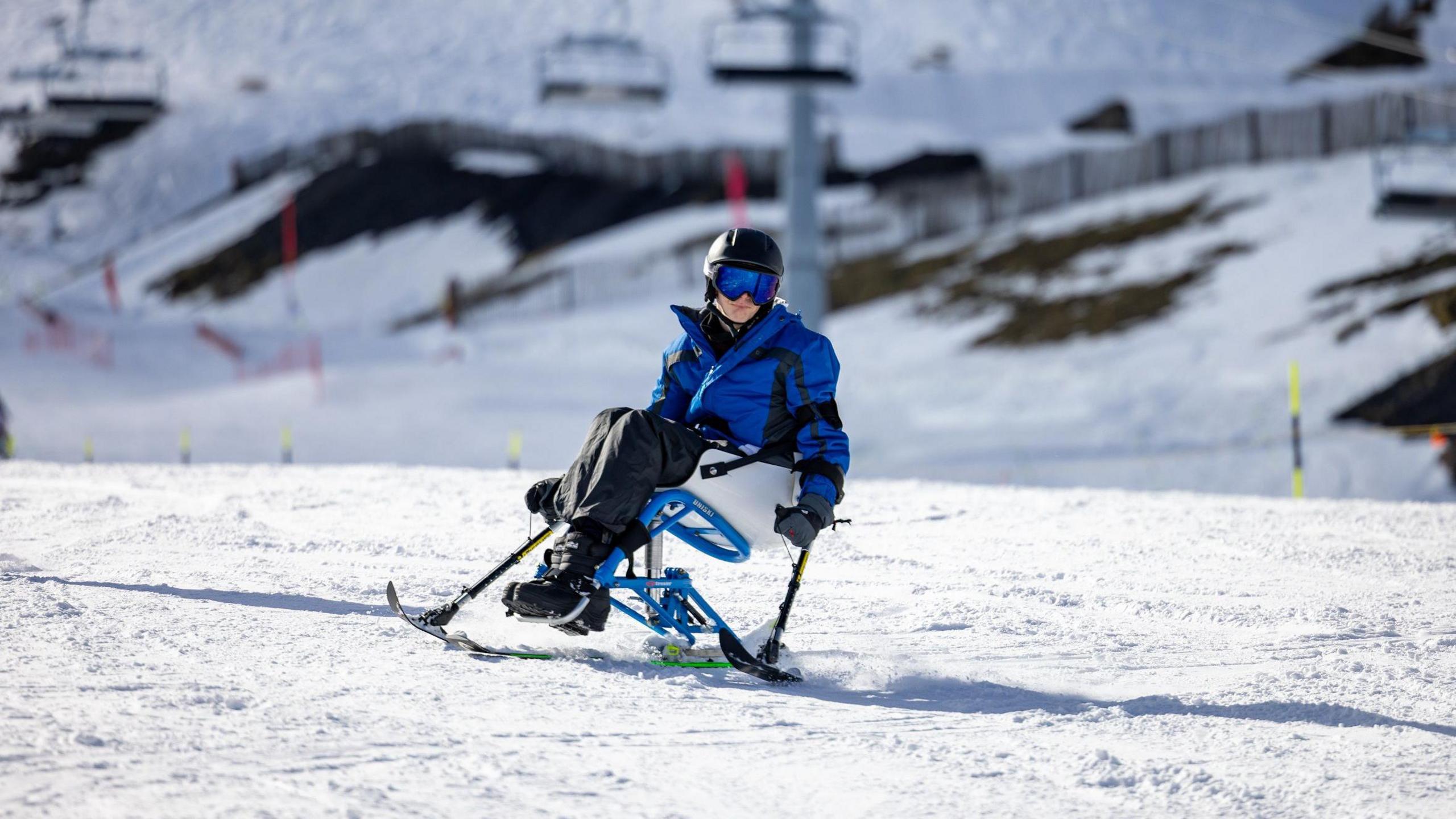 Josh skiing in the mountains on a disability ski chair