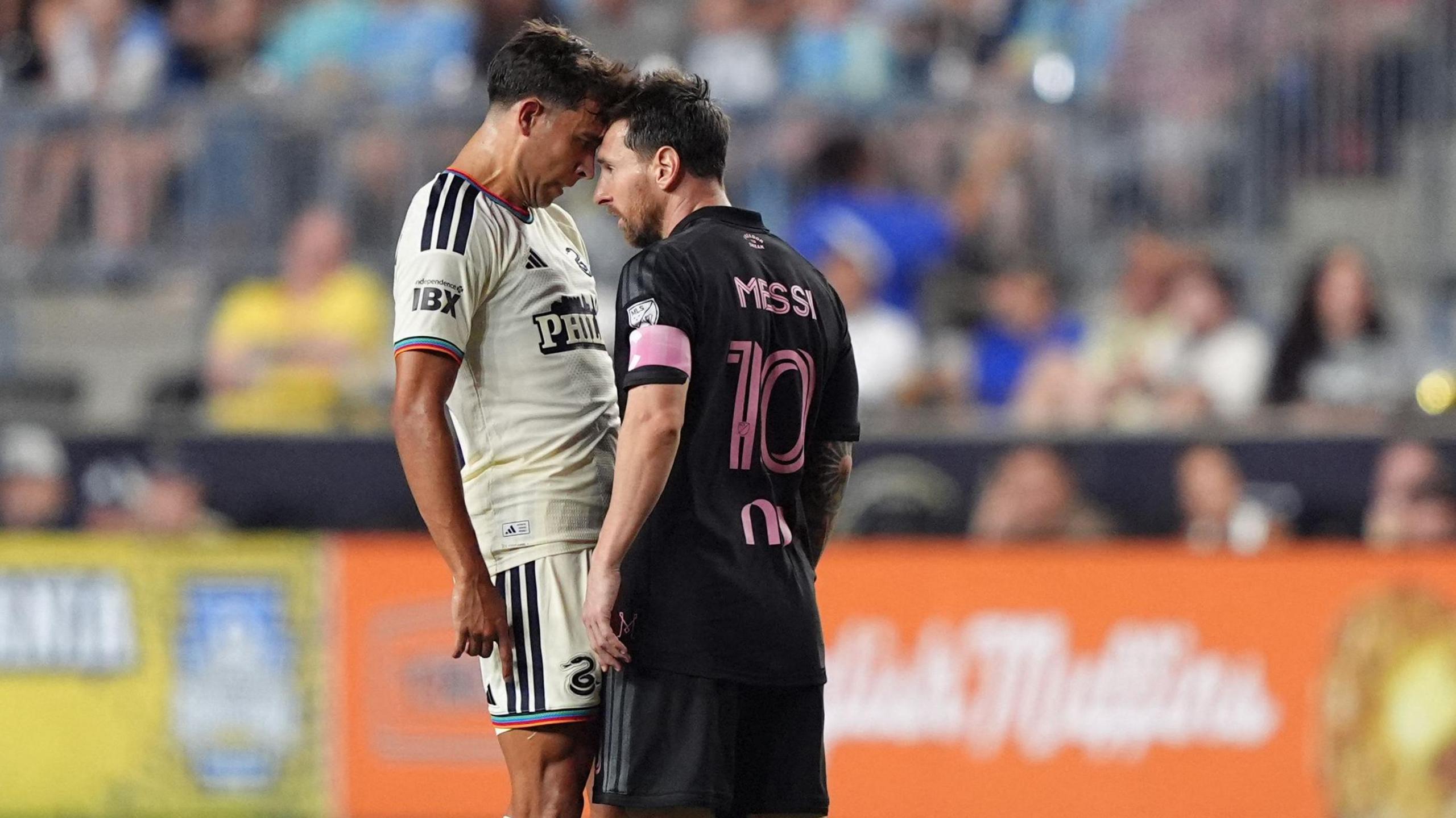 Quinn Sullivan puts his head to Lionel Messi's forehead during a game