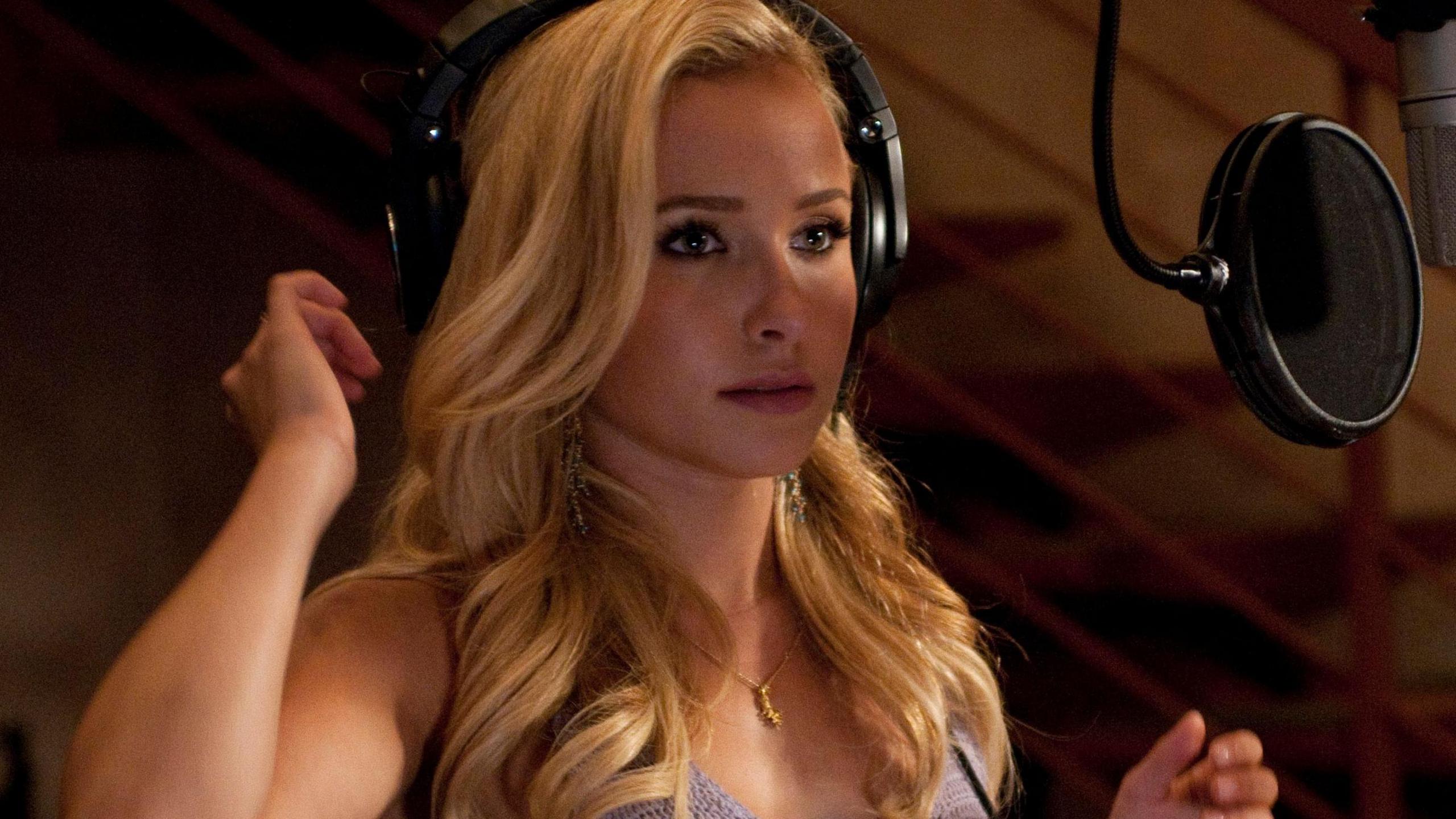 The actress playing Juliette Barnes in the TV series Nashville. She is seen here standing in front of a microphone in a recording studio with headphones on.