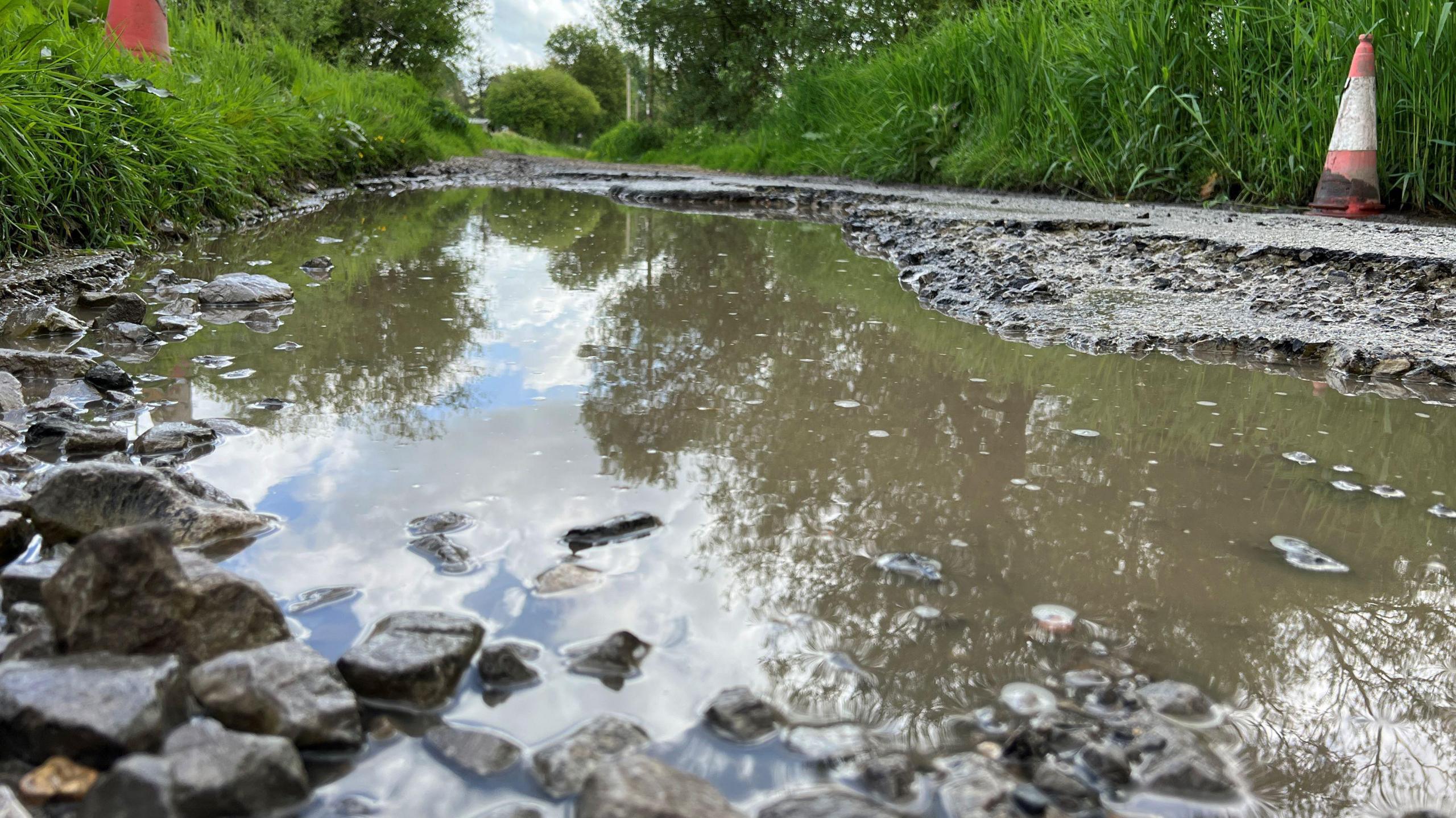 A close up shot of the pothole which is full of water