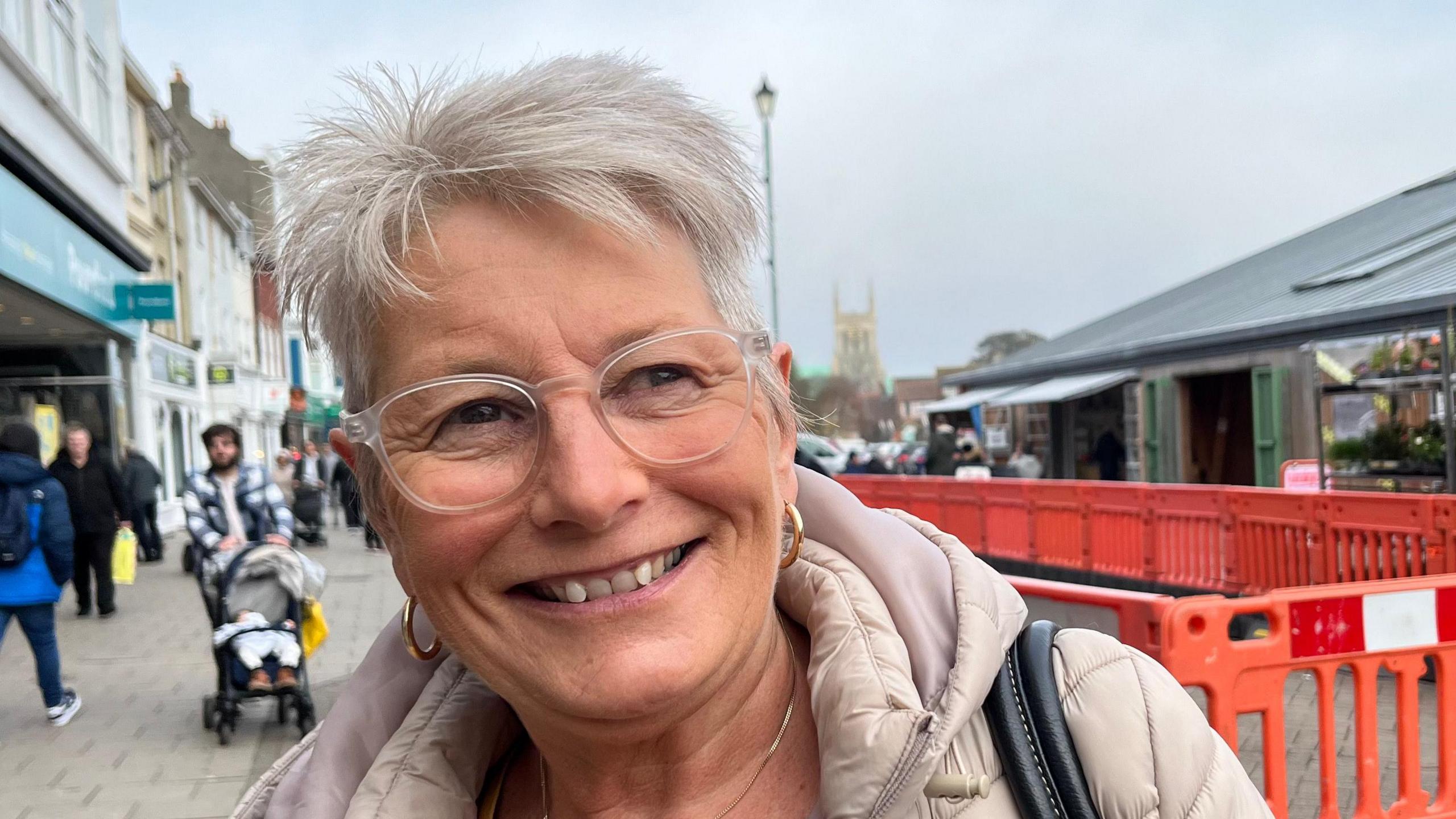 Karen Burnett in Great Yarmouth town centre. She is wearing glasses and a pinkish-grey coat.