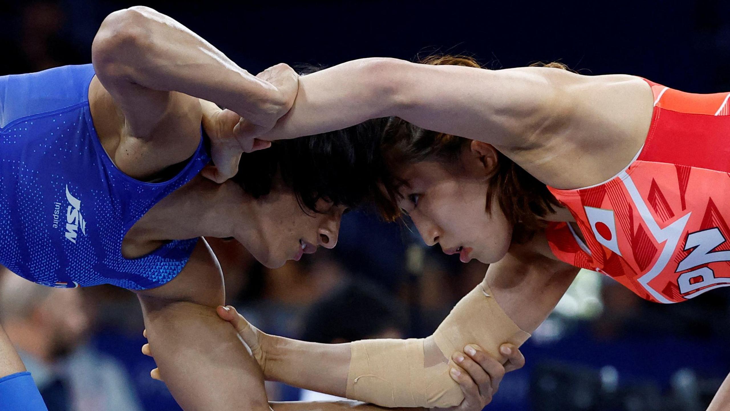 Japan's Yui Susaki (red) wrestles India's Vinesh Vinesh (blue) in their women's freestle 50kg wrestling early rounds match at the Champ-de-Mars Arena during the Paris 2024 Olympic Games, in Paris on August 6, 2024. 