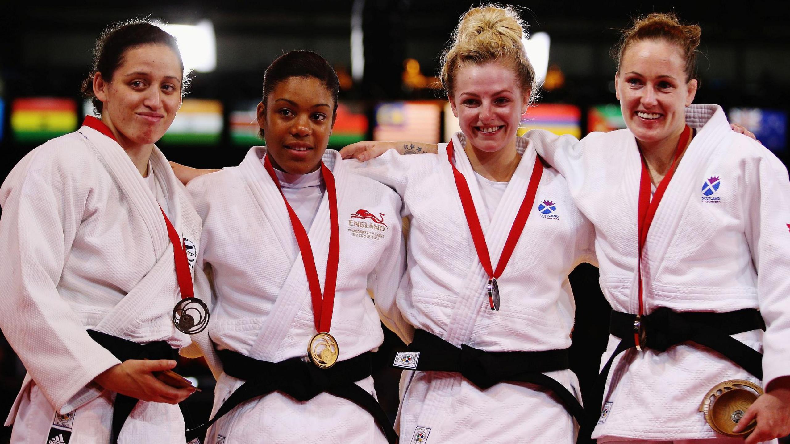 Judo medal winners Darcina Manuel, of New Zealand, Nekoda Davis, of England, and Scotland's Stephanie Inglis and Connie Ramsay. The women are standing together after competing. They are wearing white judo uniforms and have their medals around their necks.
