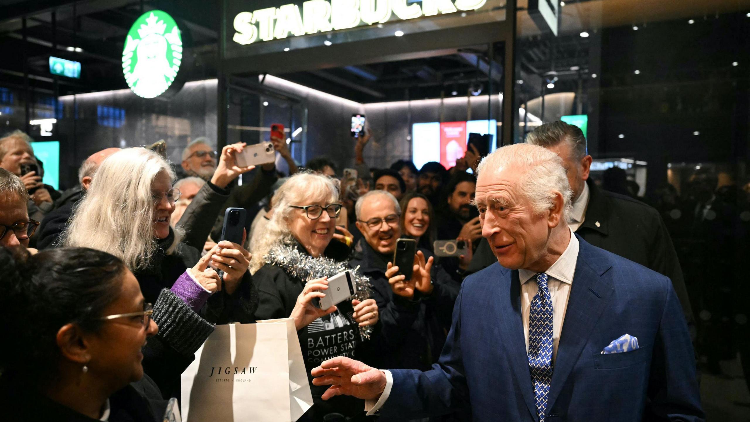 The King went over to speak to some surprised Christmas shoppers in Battersea Power Station