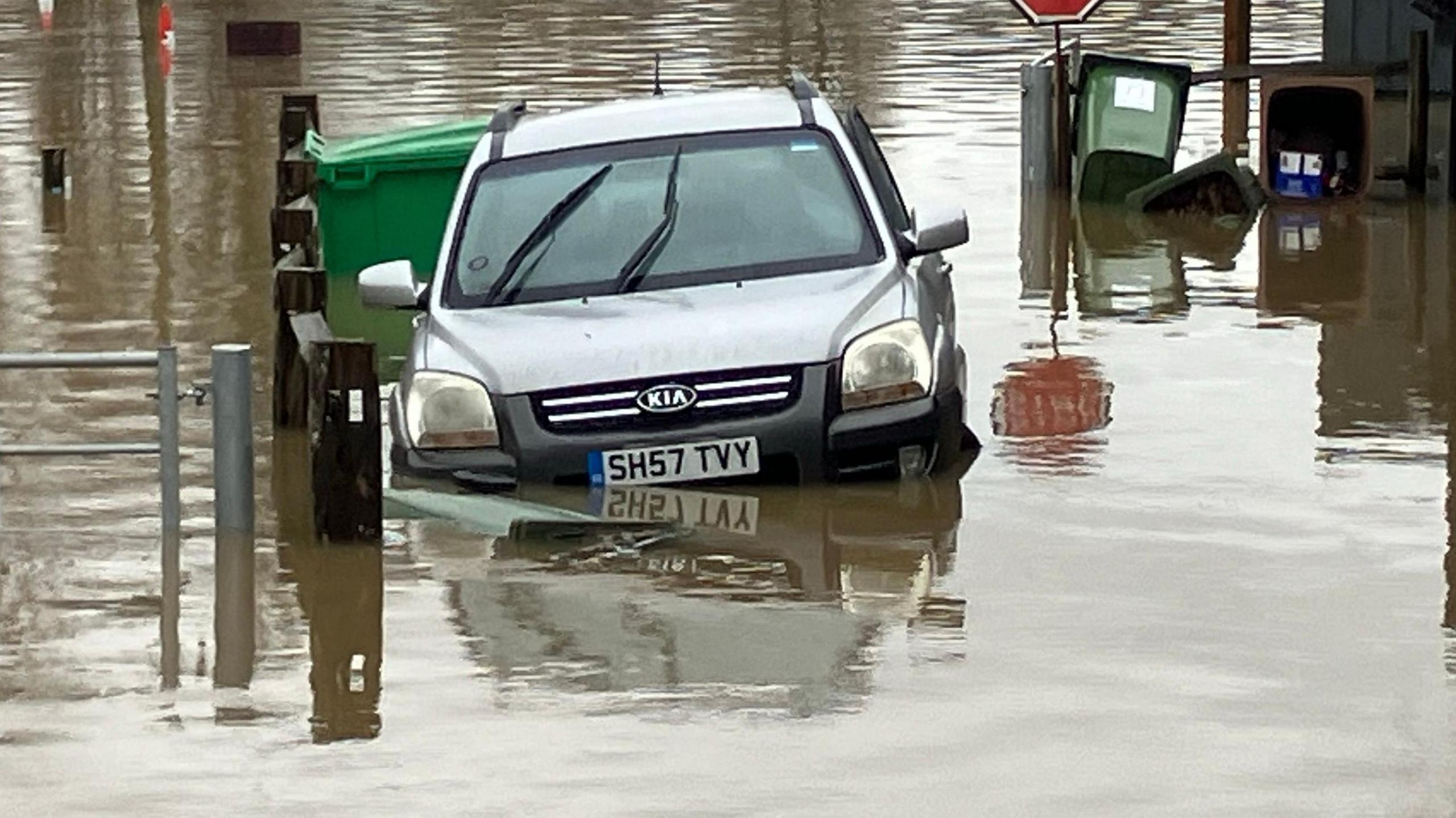 A silver KIA jeep left abandoned in a flooded area in Yalding, Kent, which is the subject of a flood warning by the Environment Agency. The silver jeep is part submerged in flood water.