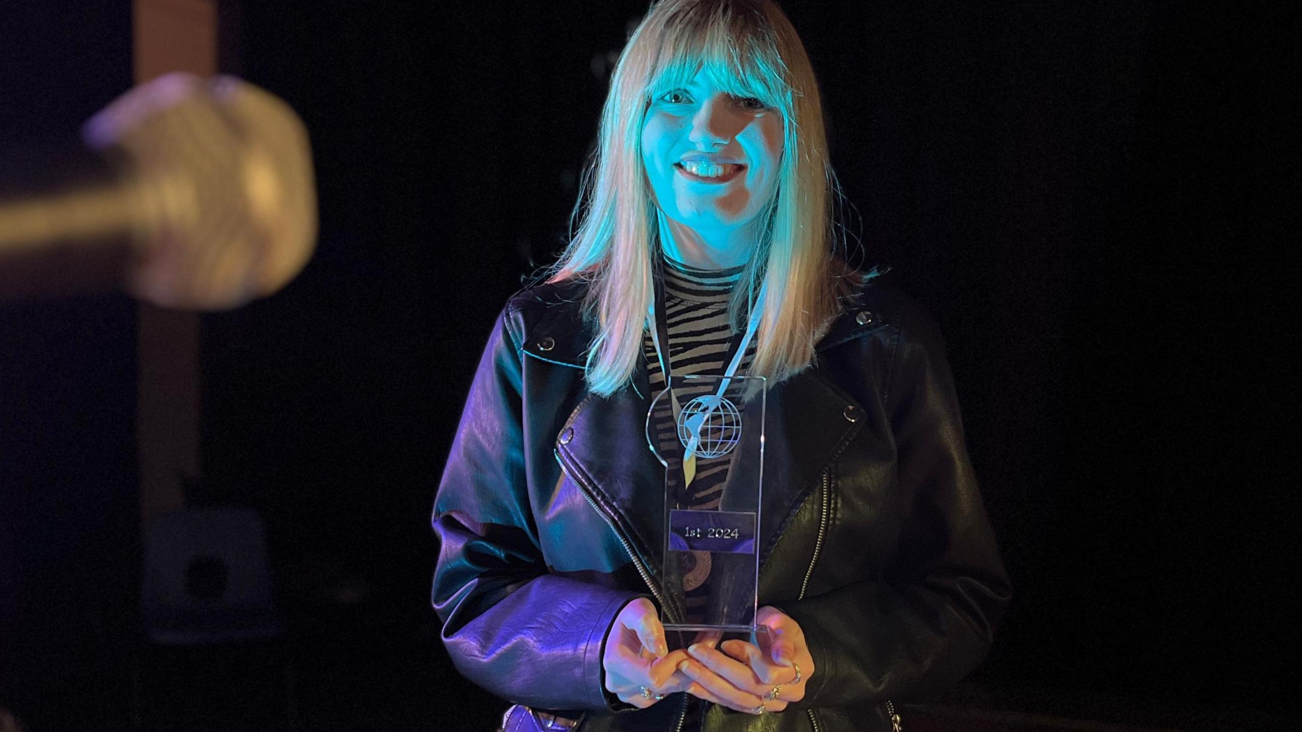 Jasmine Rose holding a winners trophy