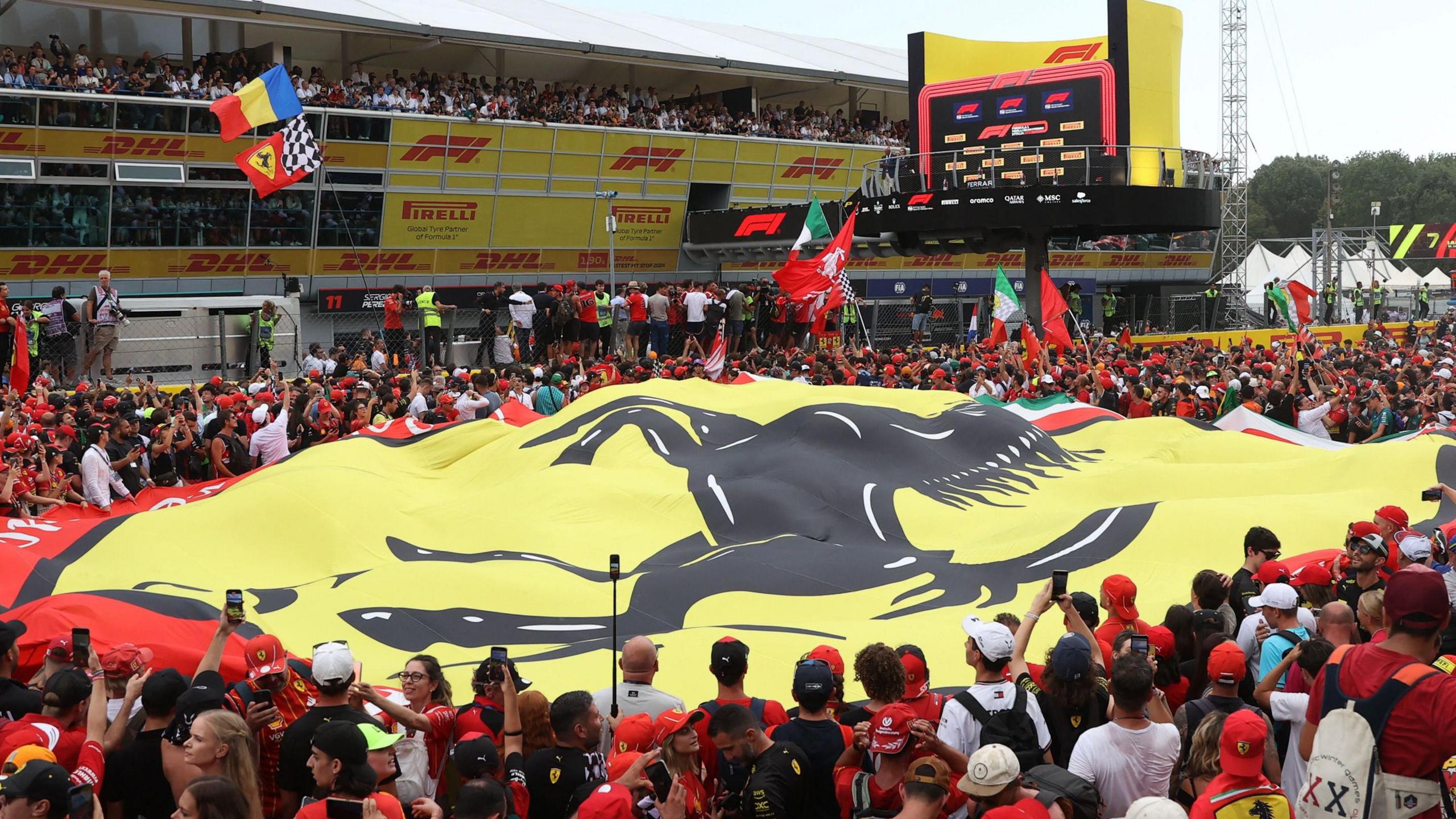 A Ferrari flag is draped over fans