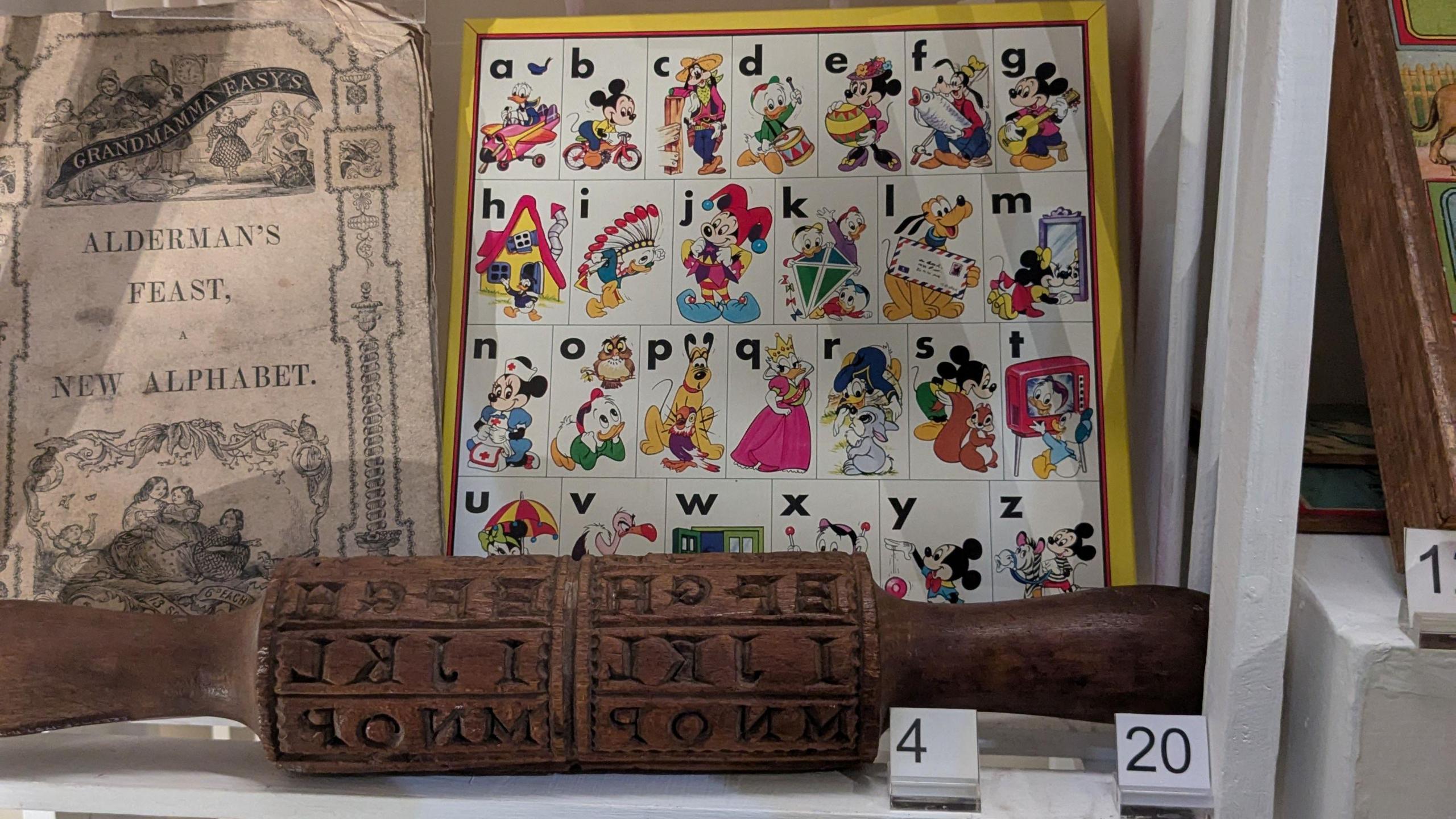 Old-fashioned alphabet toys on display, including a Disney-themed poster with Mickey Mouse and Pluto.