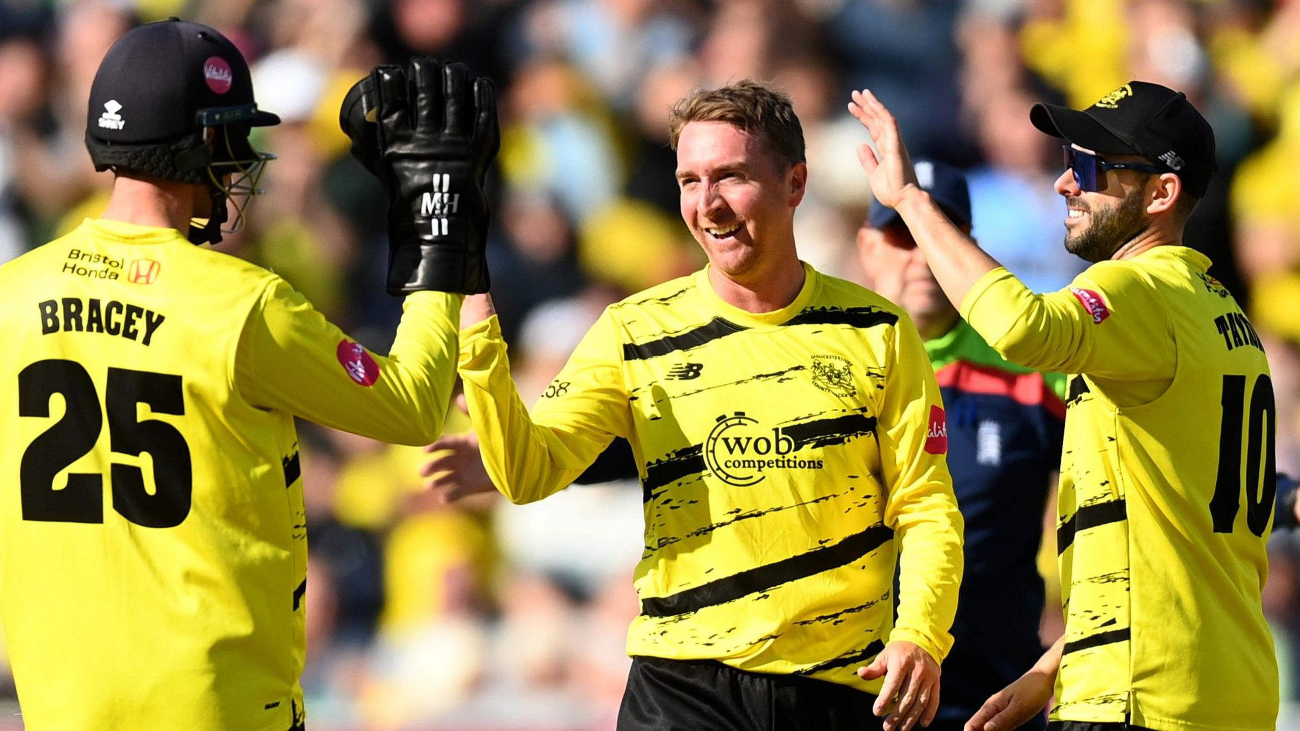 Tom Smith celebrates a wicket for Gloucestershire with team-mates