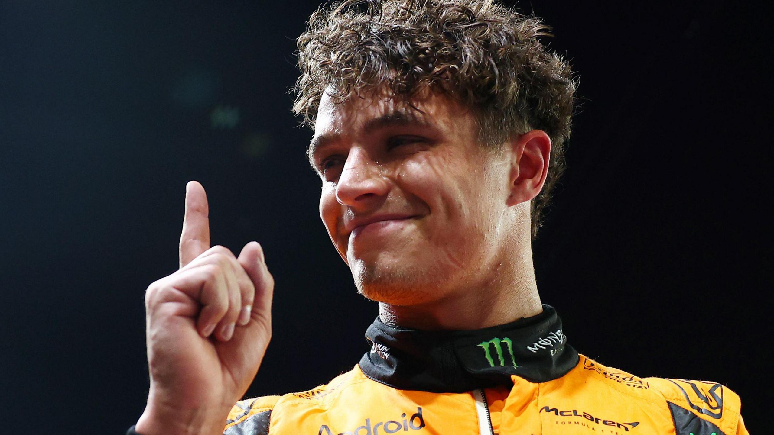 Lando Norris lifts his index finger in celebration after taking pole position for the Singapore Grand Prix