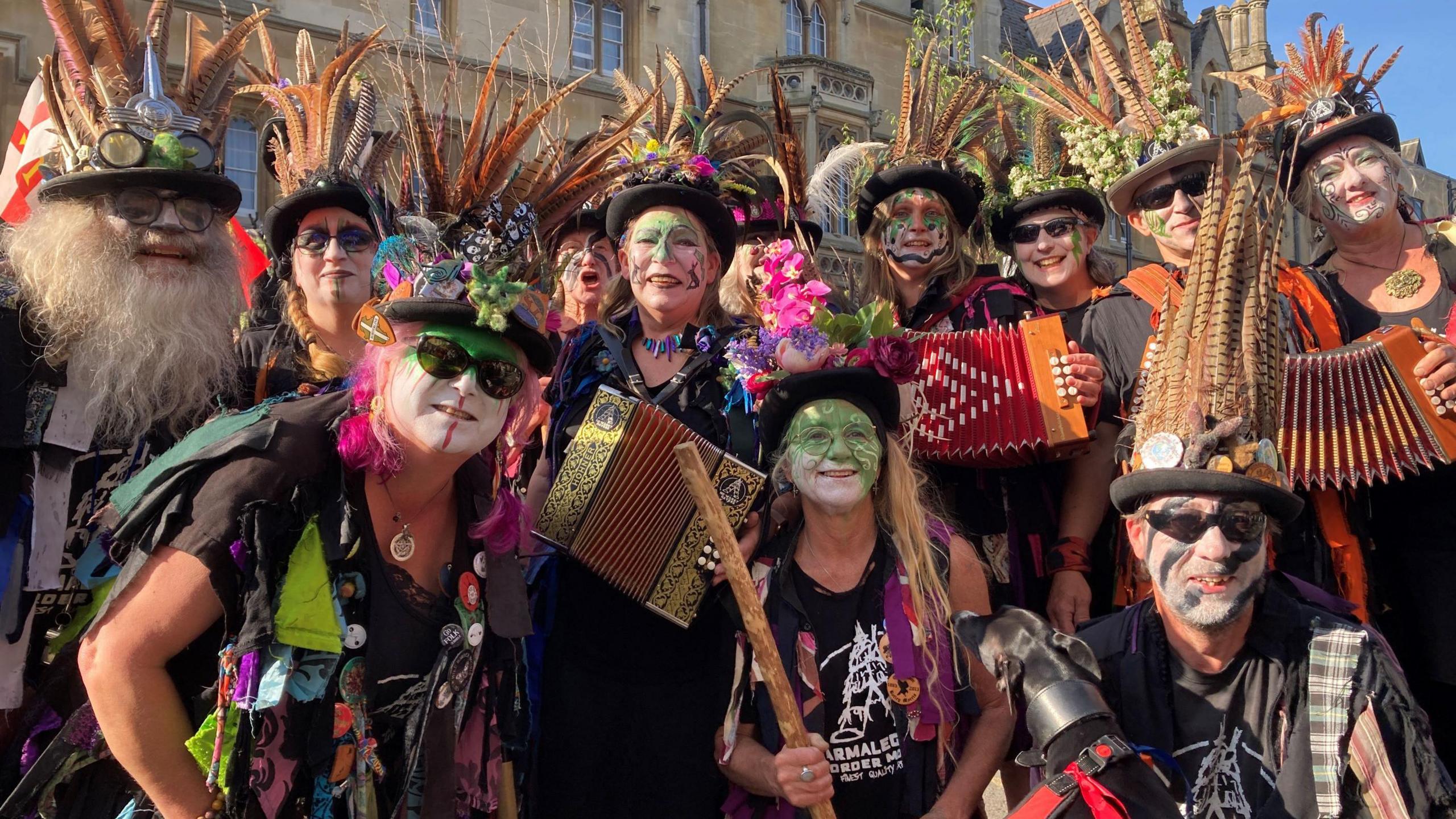 a crowd of brightly dressed people wearing traditional hats and holding accordions  