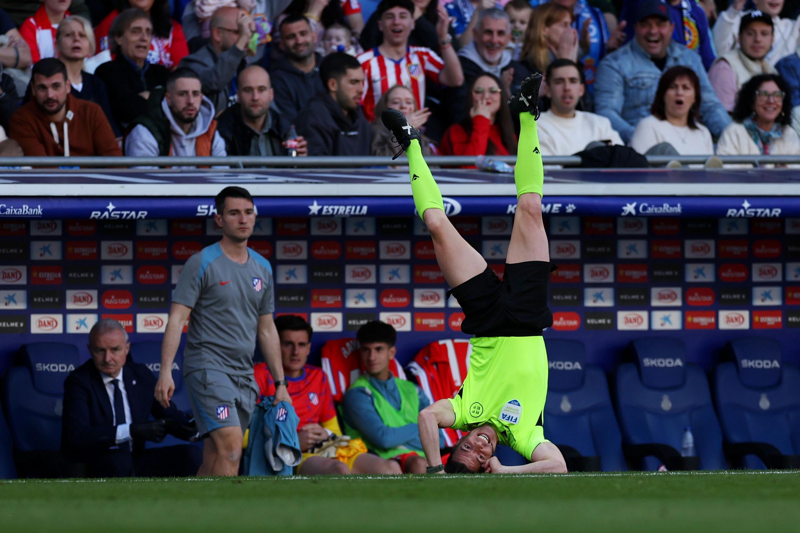 Assistant referee Rodriguez Moreno falls after colliding with Atletico Madrid's Giuliano Simeone during the La Liga match at Espanyol