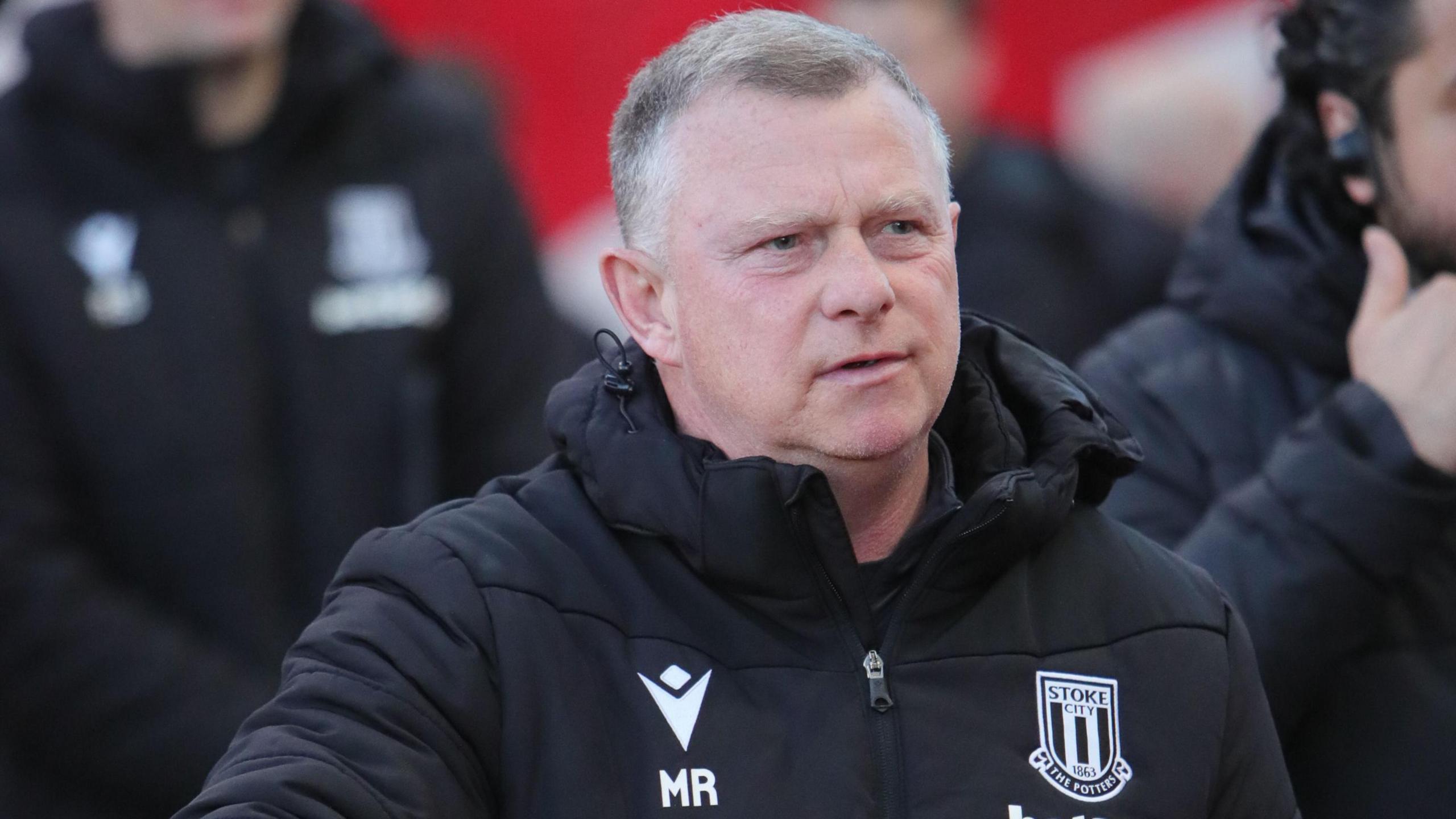 Stoke City boss Mark Robins walks towards the changing room after a game