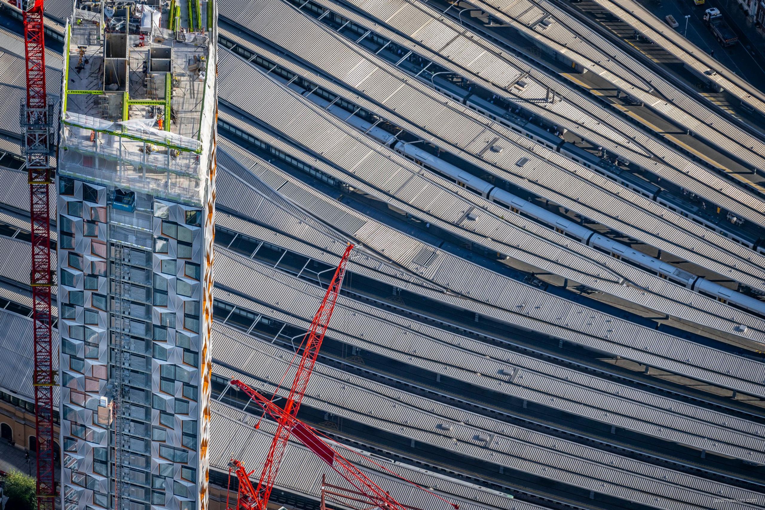 skyscraper being built over railway