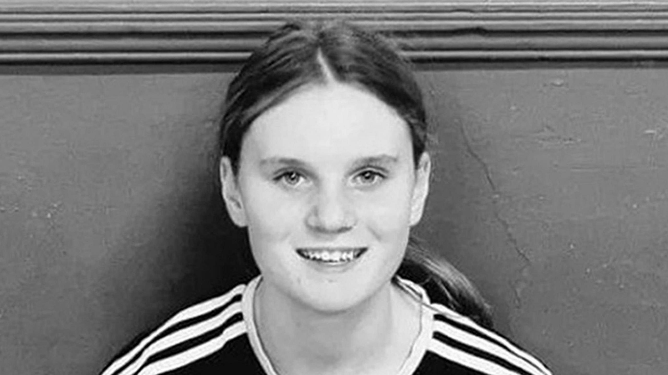 Black and white picture of a teenage girl with long hair in a pony tail