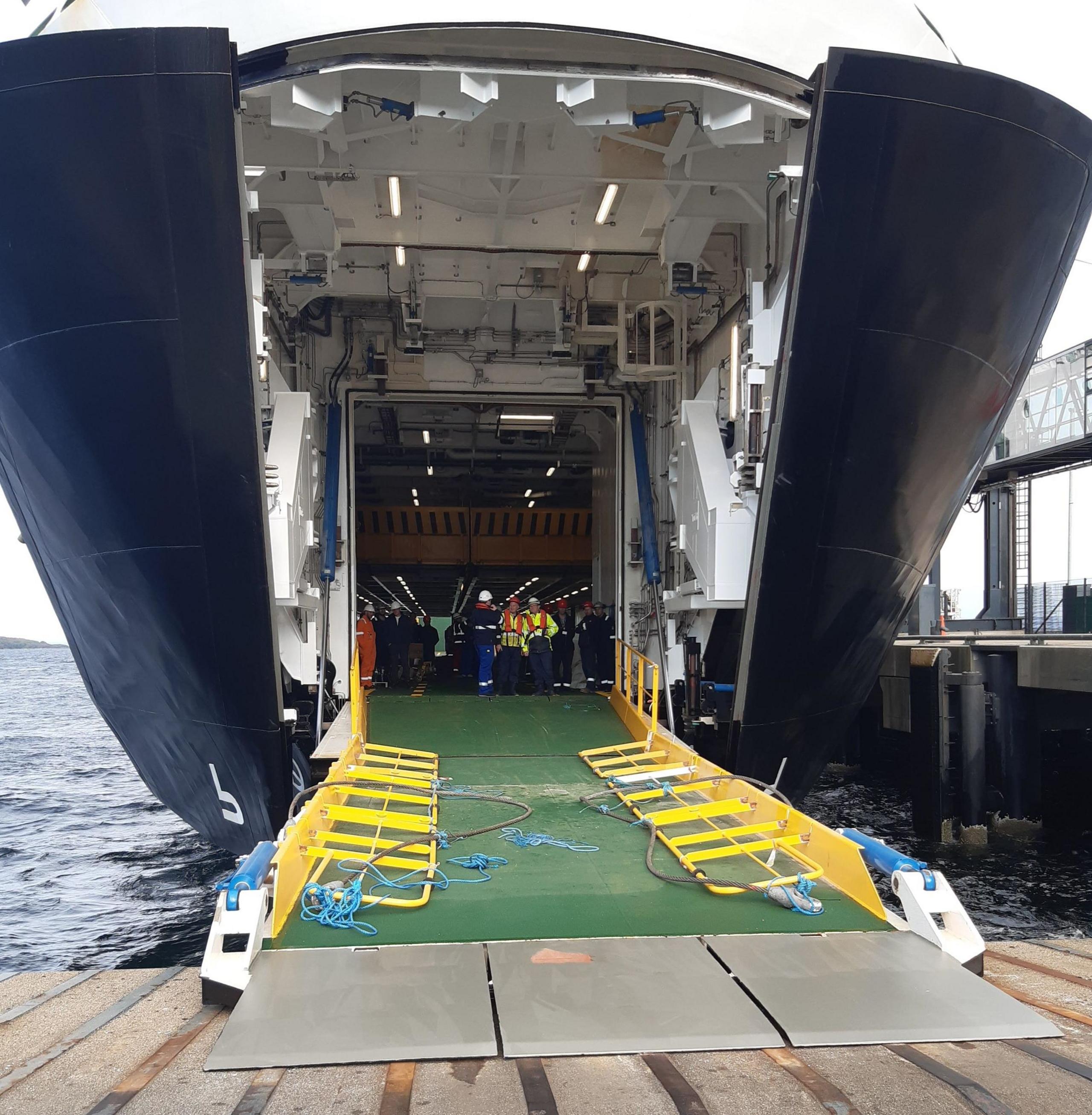 Open clamshell doors and a green painted ramp on the bow of Glen Sannox as it berths at Brodick