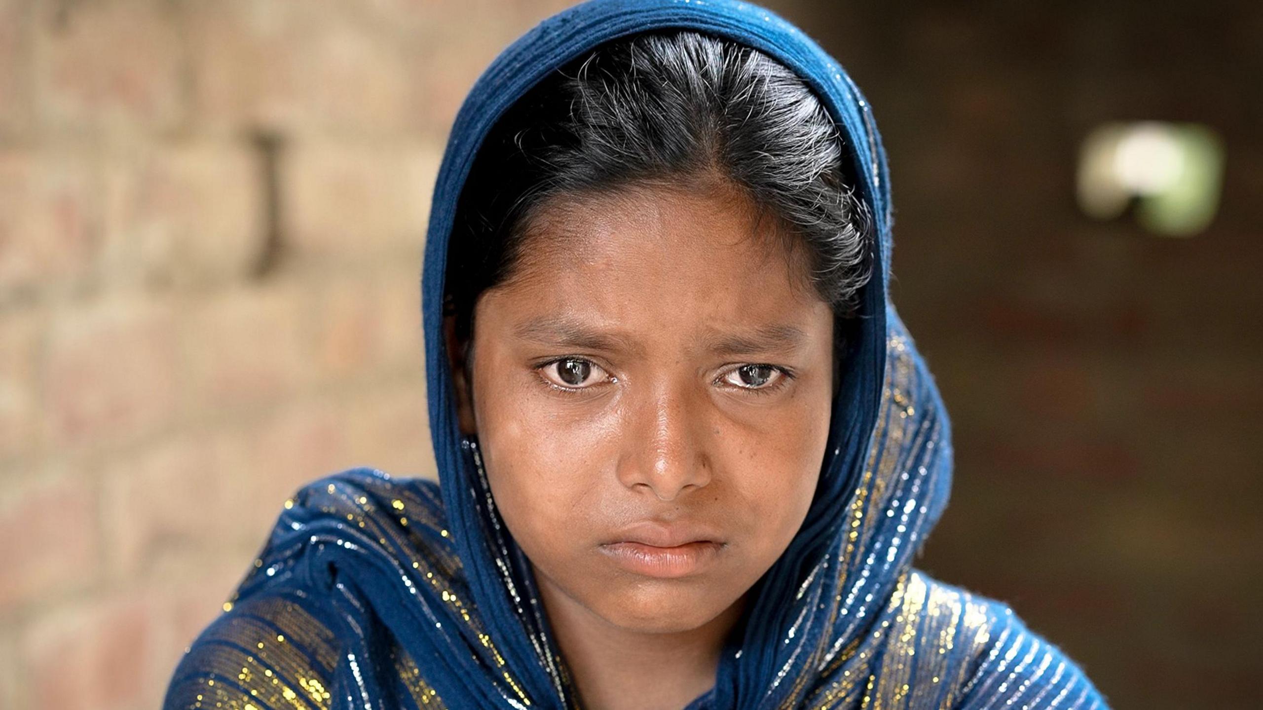 Sabina Khatun, wearing a shawl, looks sad