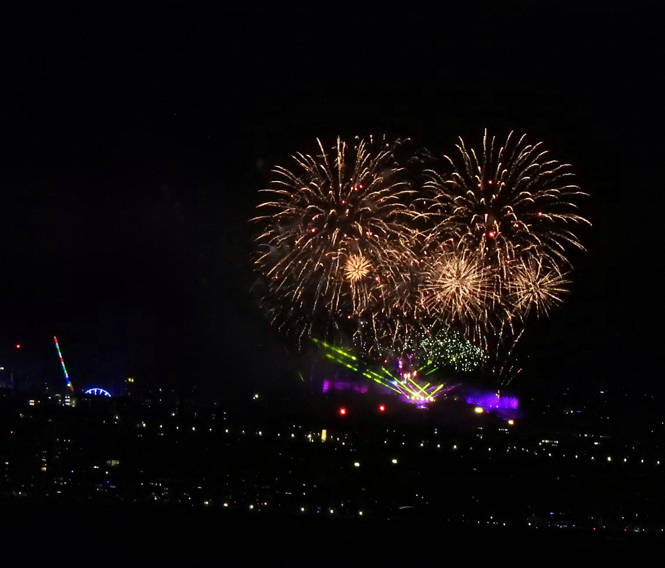 Fireworks in a heart-shaped display. There is a stage with lights underneath.